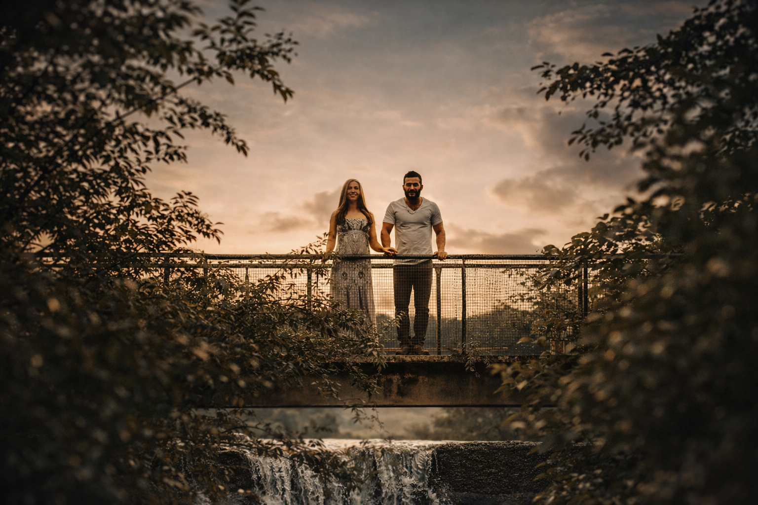 Expecting couple standing together on a bridge during a fine art maternity photography session surrounded by nature
