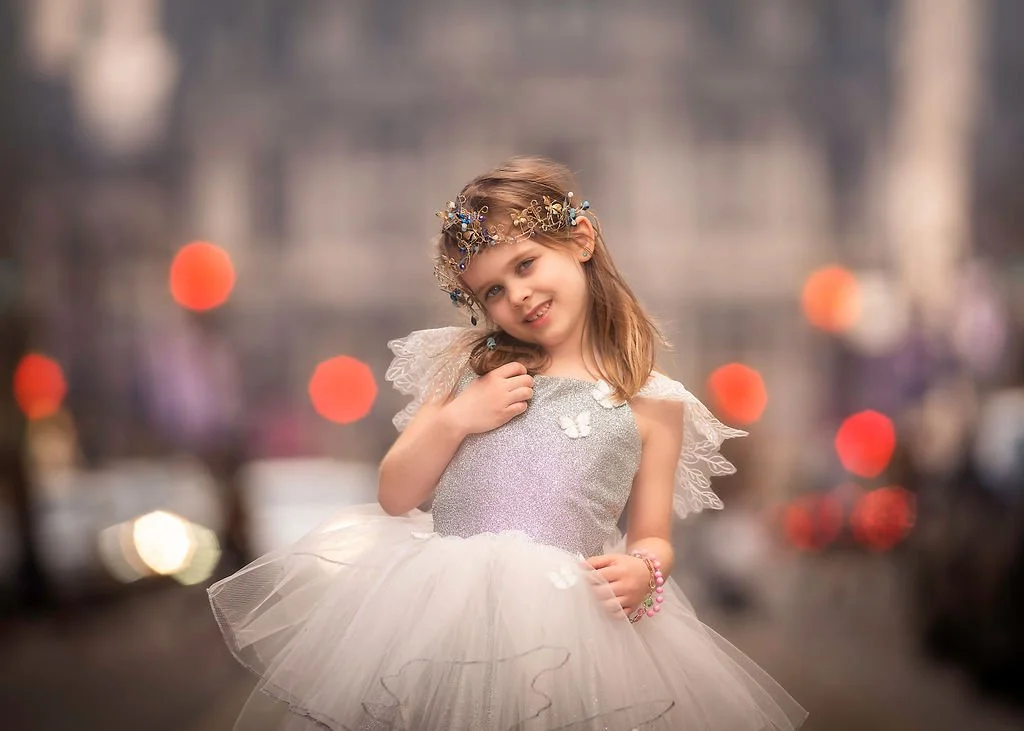A little girl posing for a natural light headshot during a family portrait session on Broad Street in Philadelphia.