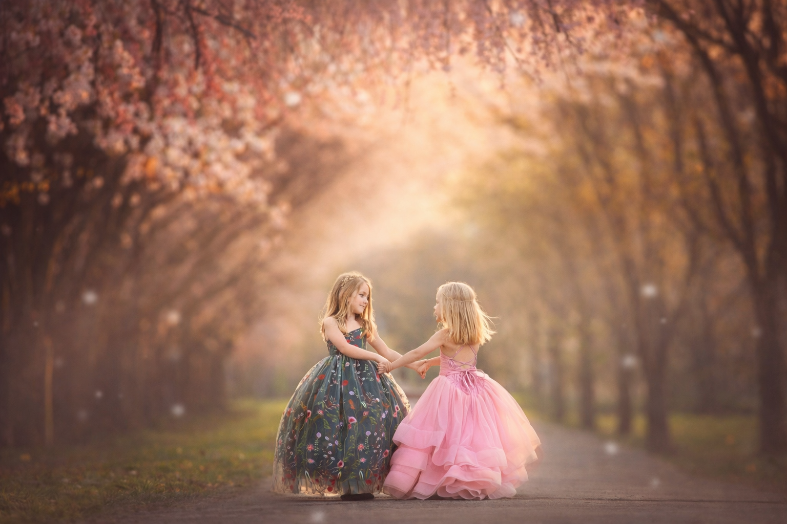 Young girls standing under cherry blossom trees in Fairmount Park Philadelphia during a spring portrait session.