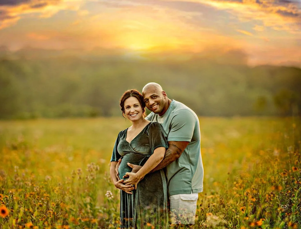 Father holding pregnant mother’s belly during a sunset maternity session in a wildflower field in South Jersey.