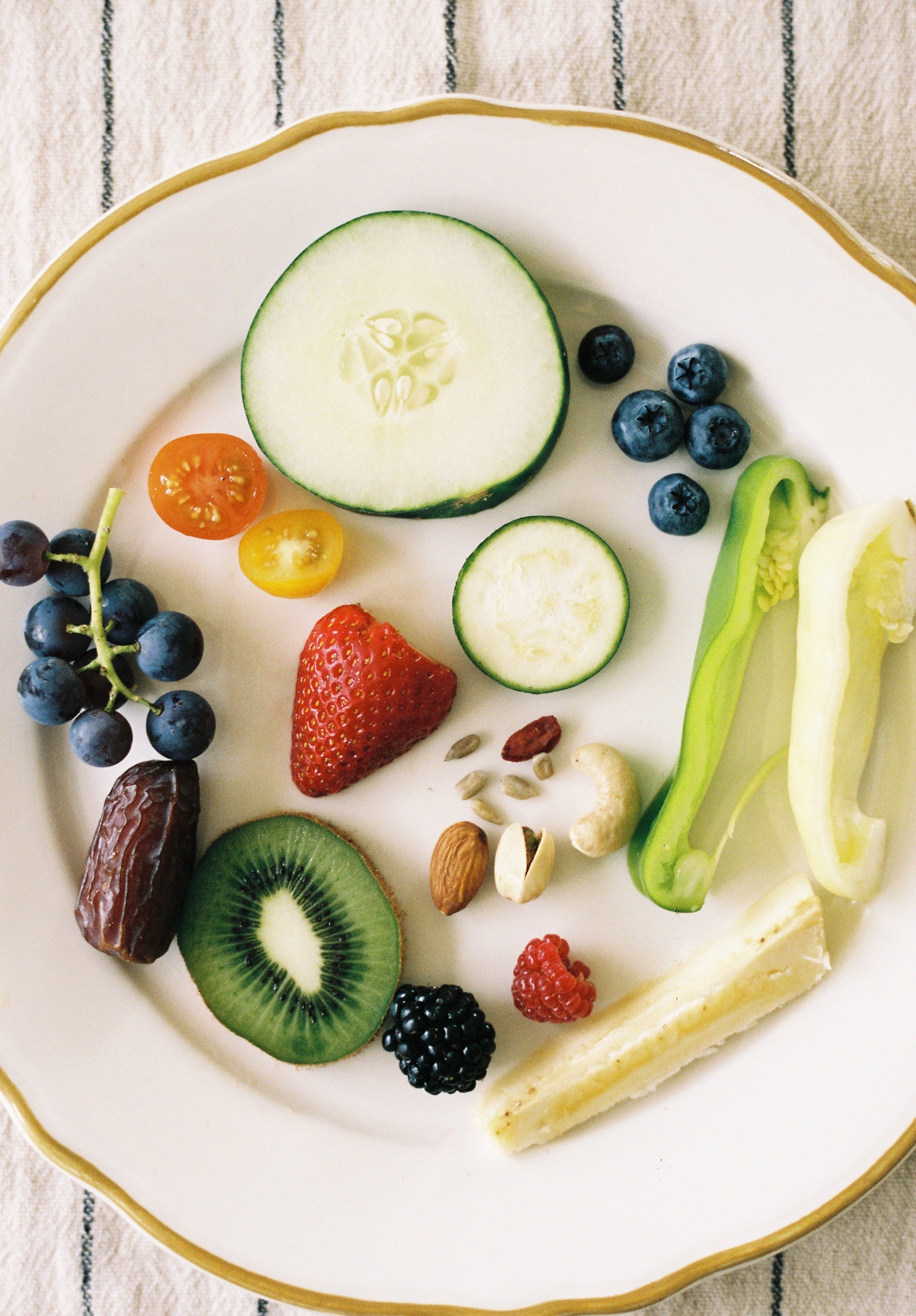 A flat lay of a variety of fruits and vegetables with seeds on a plate.