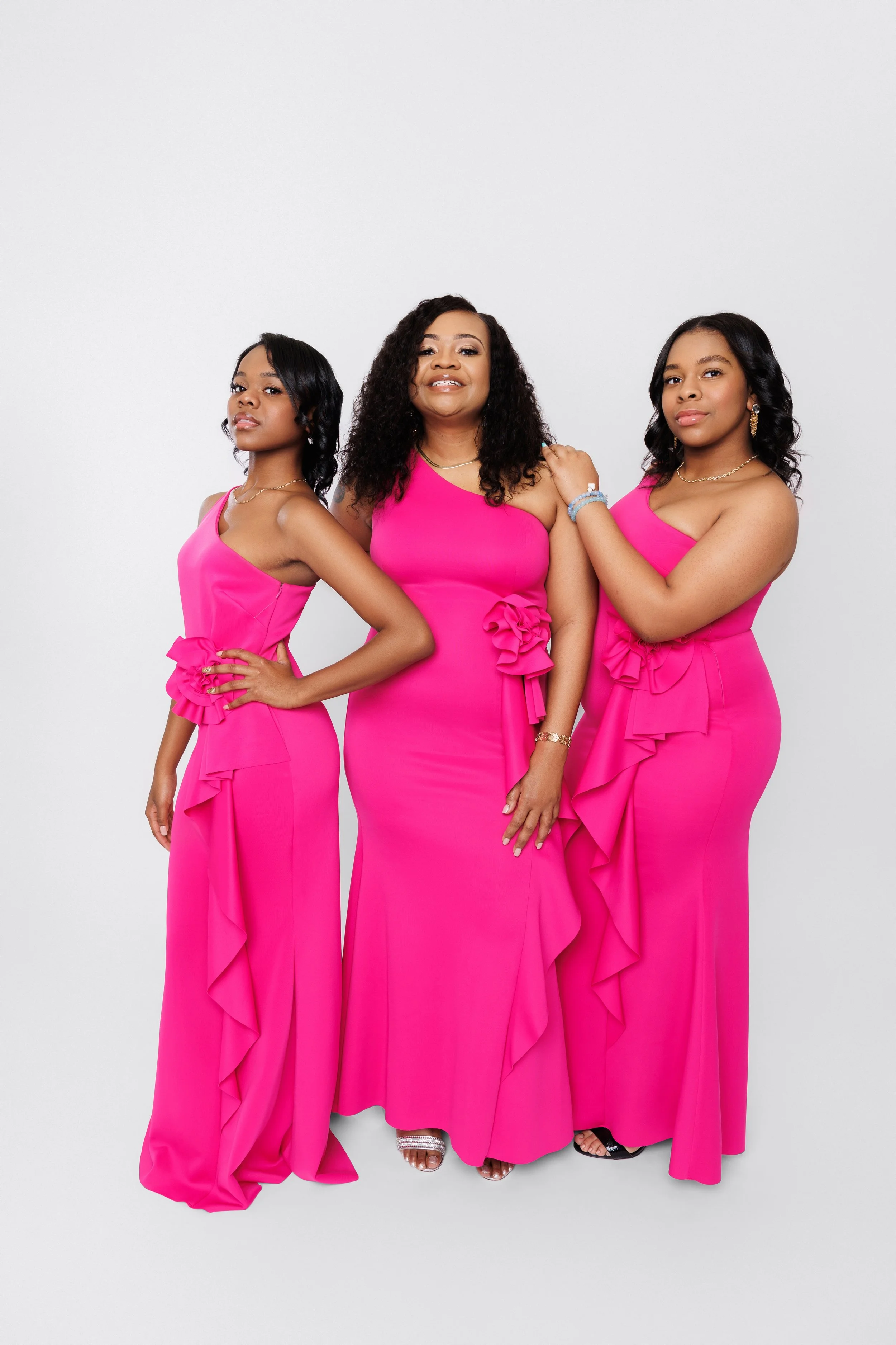 Mother and daughters wearing matching pink dresses posing for a family photoshoot in Memphis Tennessee