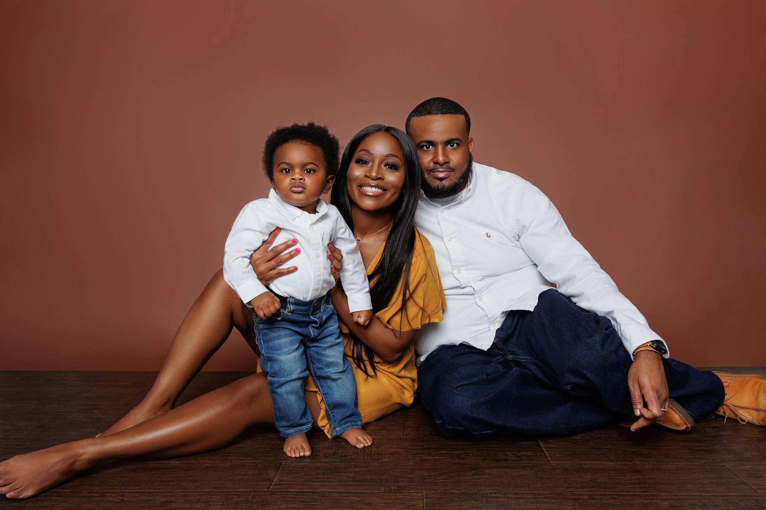 Family with toddler sitting on floor during studio portrait session in Memphis TN