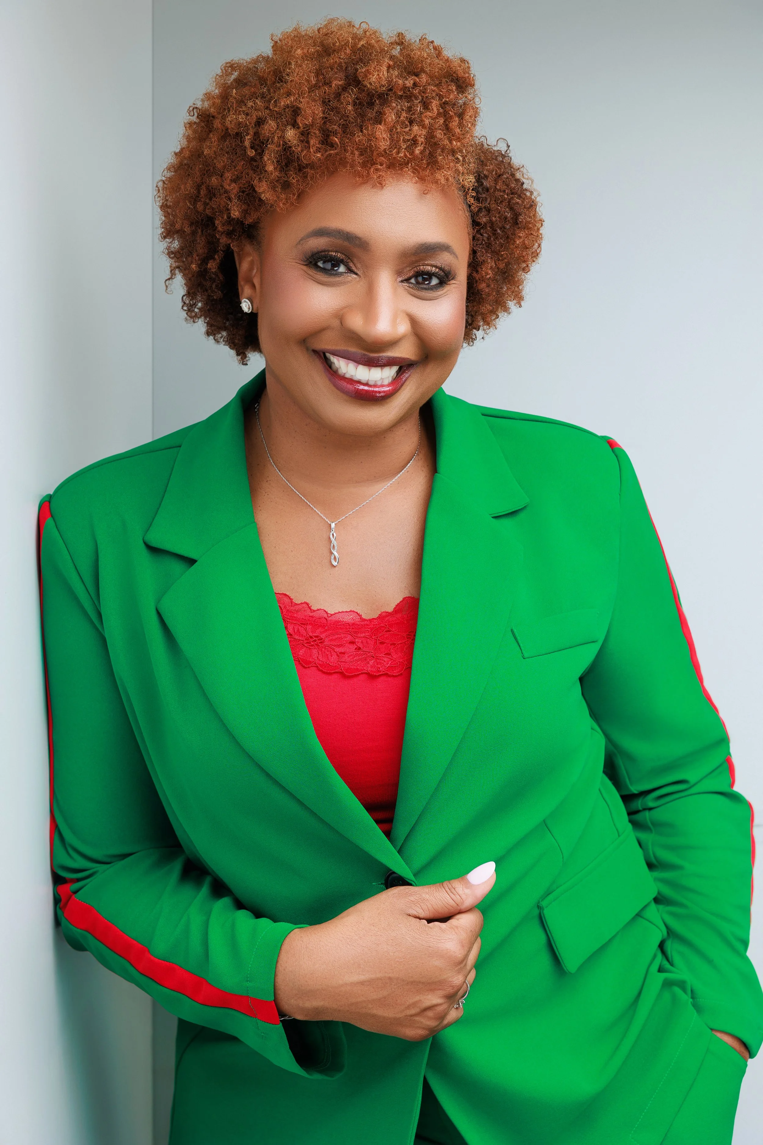 Professional branding portrait of woman in green suit smiling during Memphis empowerment photoshoot