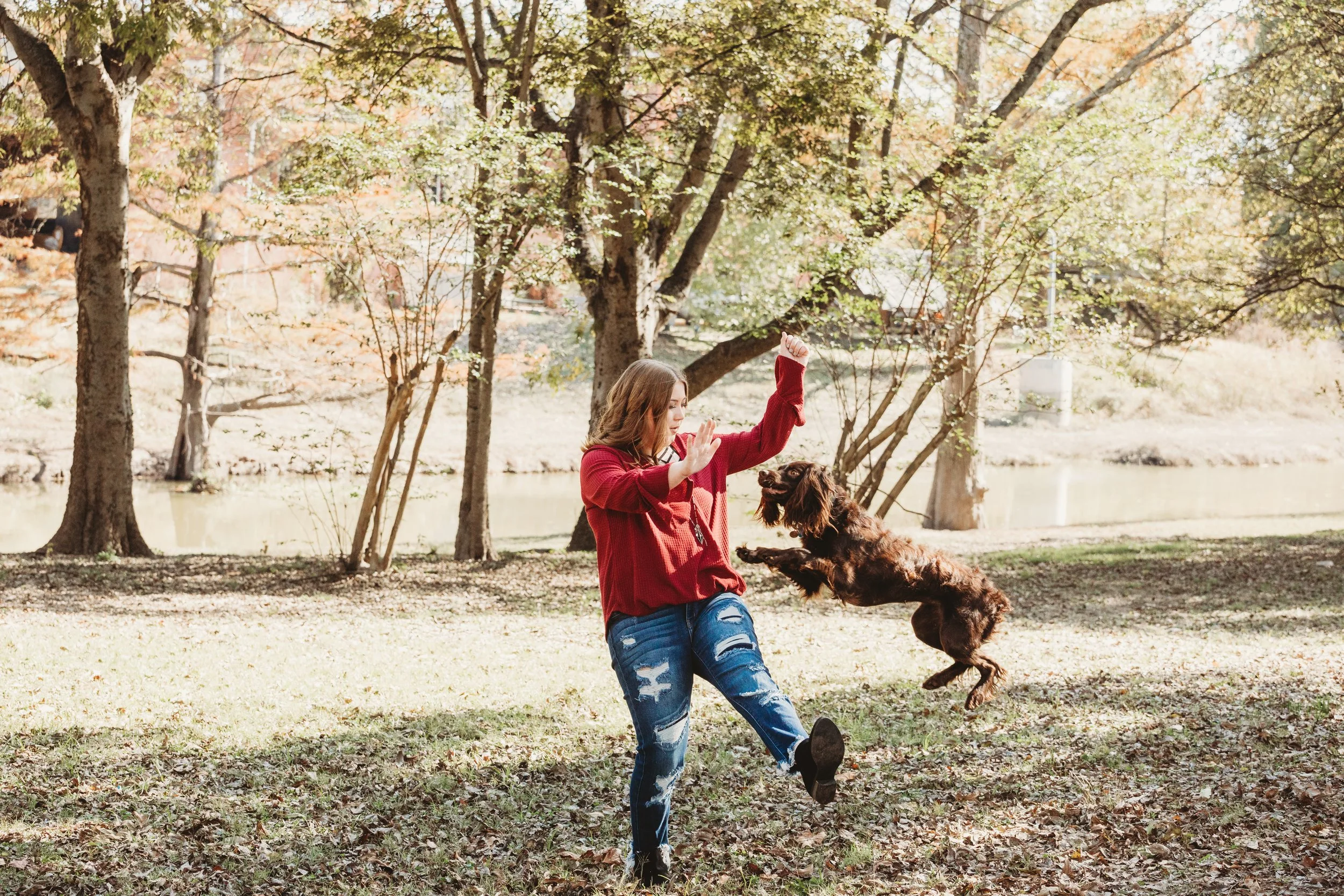 Action shot of Caitlyn’s dog jumping during an outdoor senior photo session in Memphis Tennessee, capturing dynamic movement and fun pet photography moments.