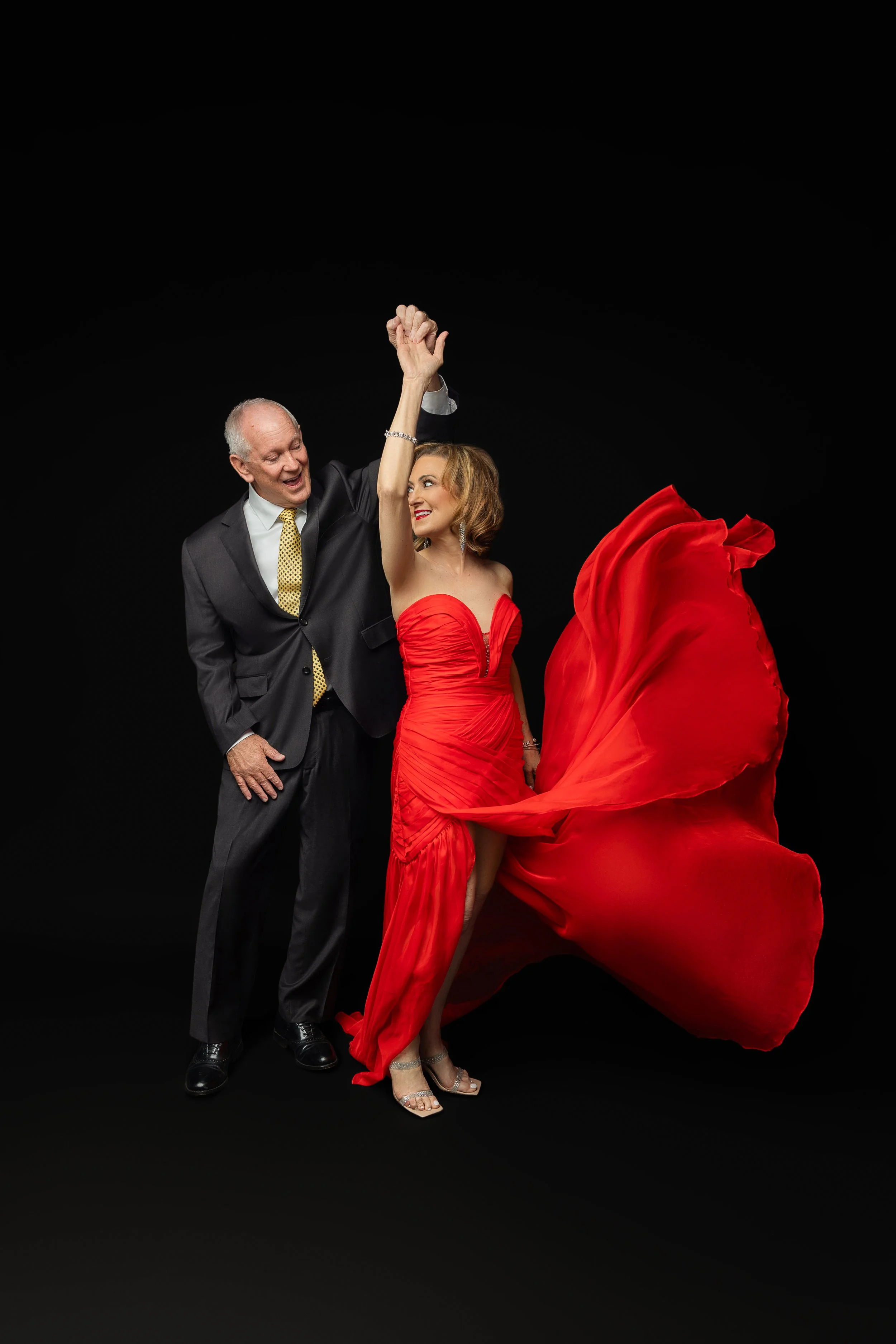 Couple married over 50 years dancing together during a luxury couples portrait session in Memphis Tennessee, woman in red gown celebrating love and legacy photography