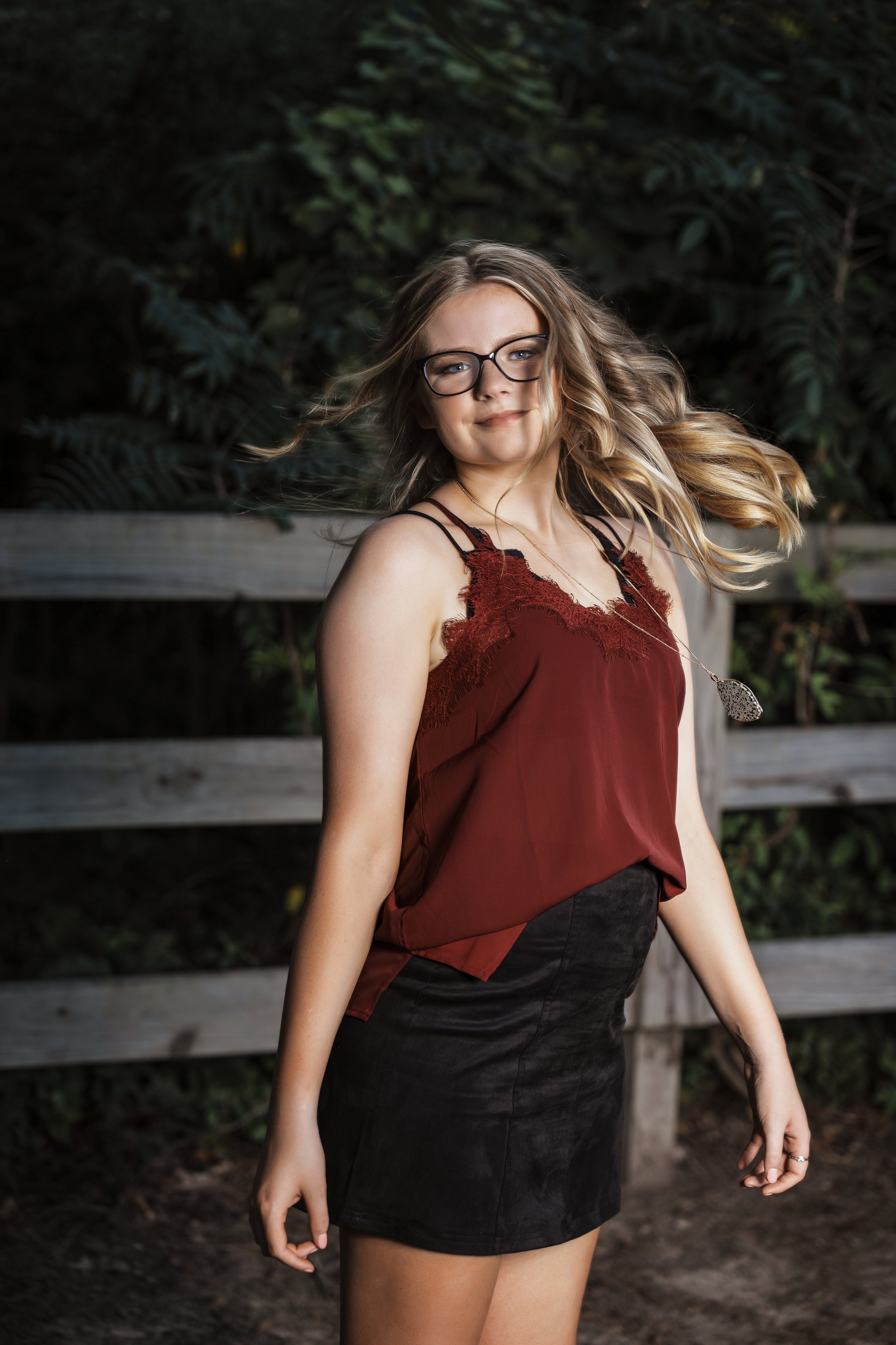 Memphis Tennessee senior photography portrait of Molly in a burgundy lace top and black skirt with soft outdoor lighting