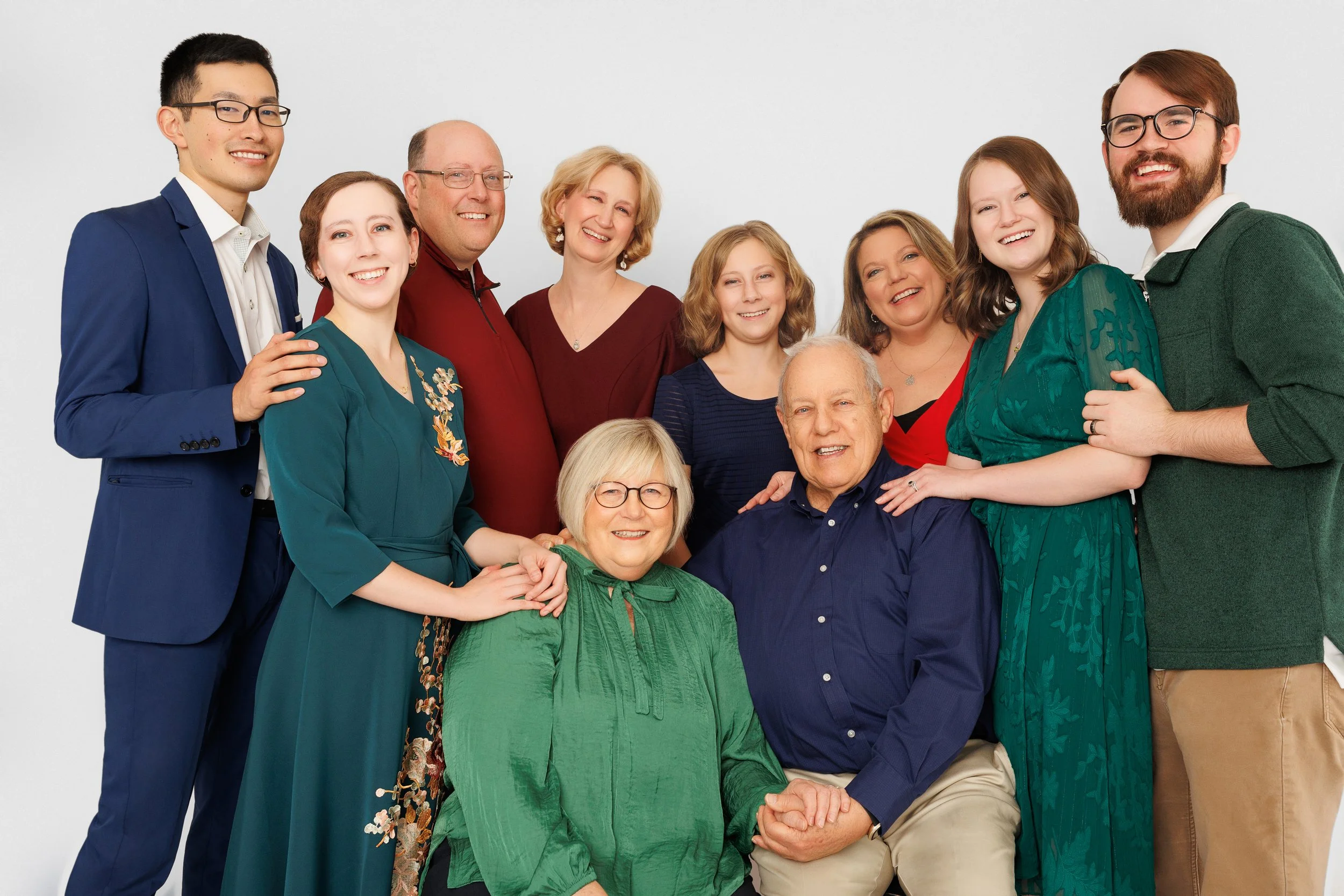 Extended family portrait with multiple generations smiling against a white background in Memphis TN