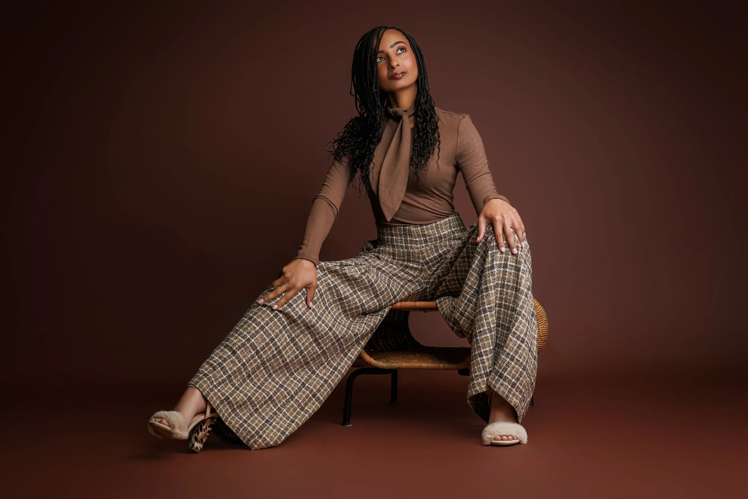 Editorial style portrait of woman sitting confidently in plaid pants during Memphis beauty photoshoot