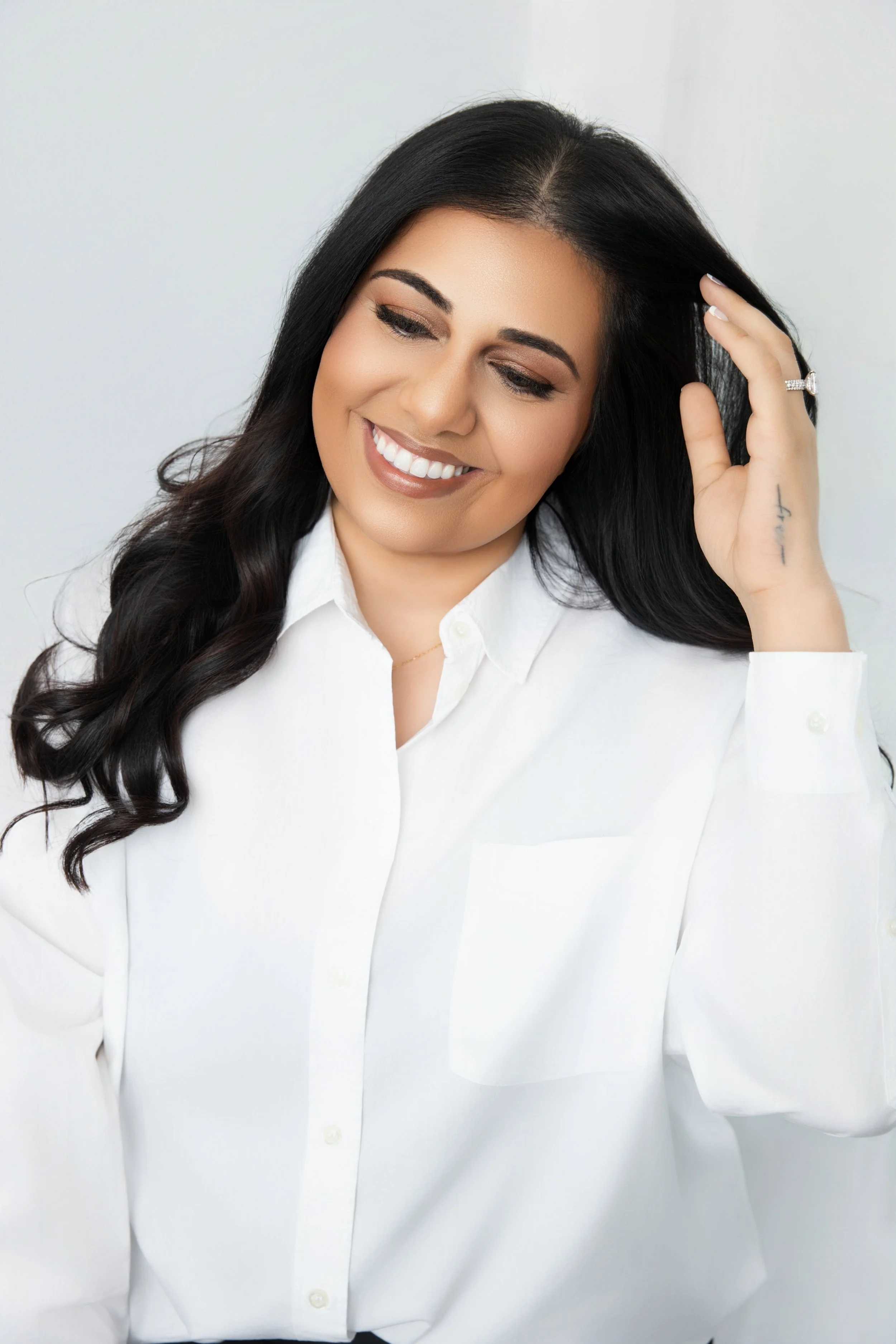 natural, modern headshots of a smiling woman in a white blouse with long dark hair, photographed by hadonica's photography in memphis tennessee, memphis tennessee headshot photographer 