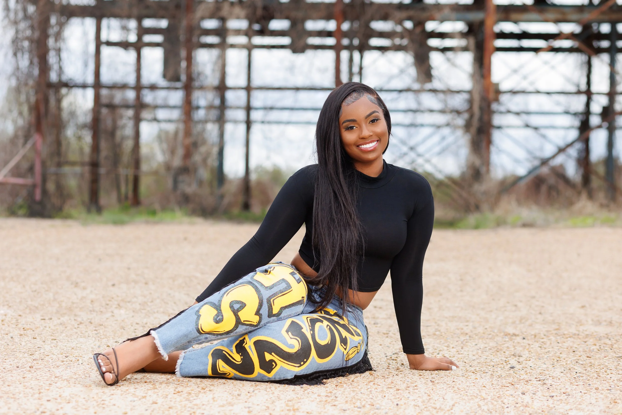 Outdoor senior portrait of Memphis Tennessee graduate wearing custom Alcorn State jeans photographed by Hadonica’s Photography