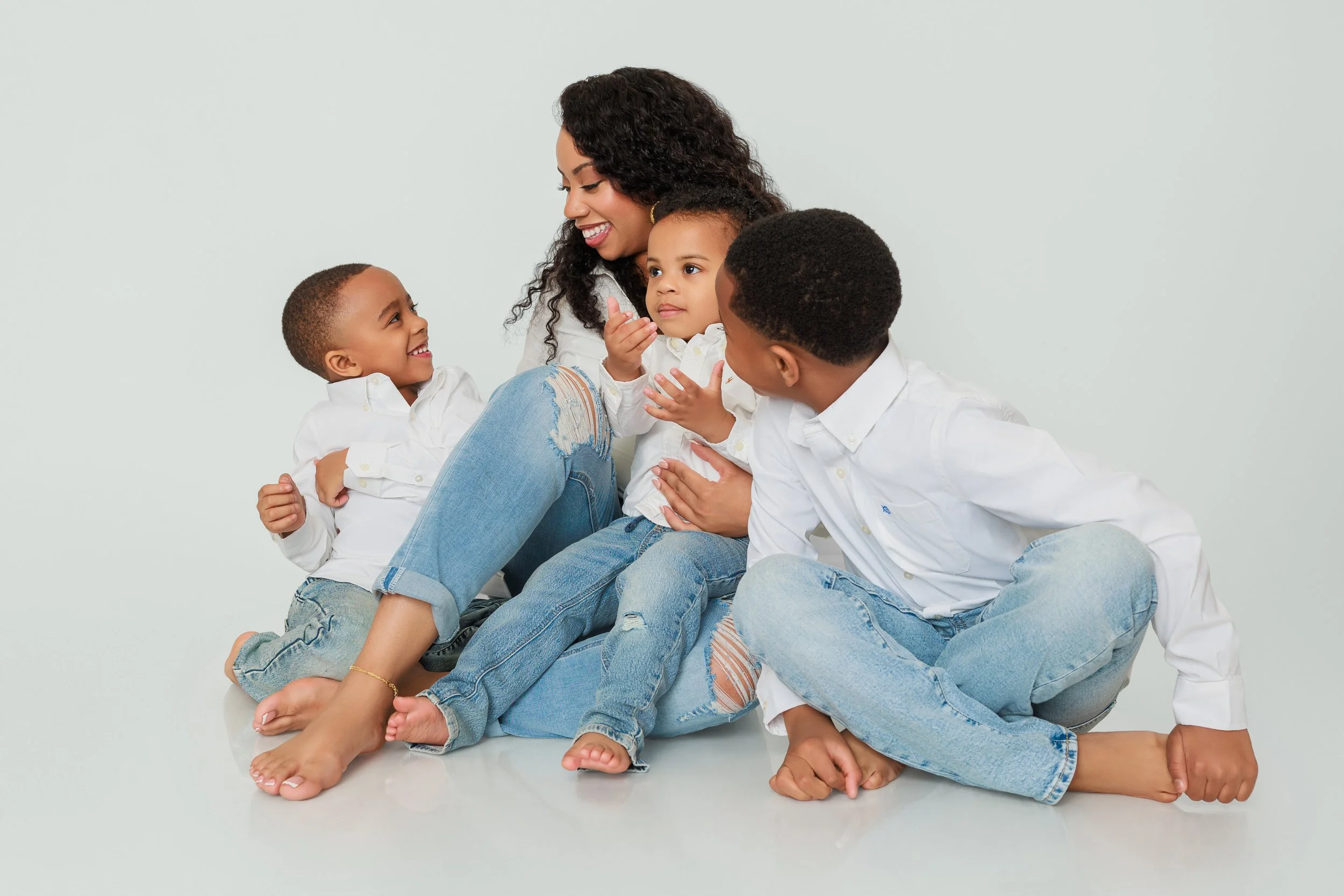 Mother interacting with her children in a candid family moment during studio photoshoot in Memphis TN