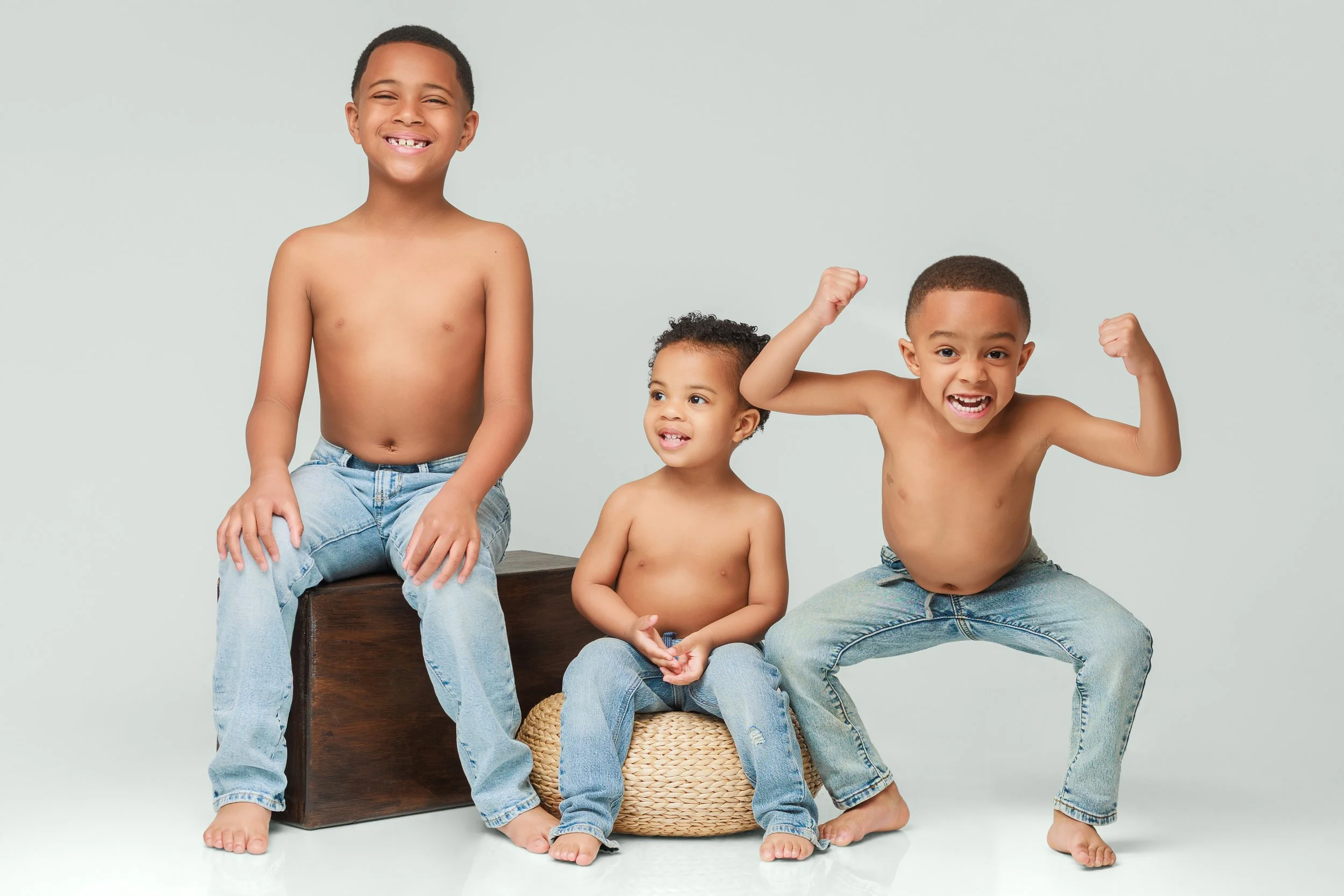 Three young brothers smiling and playing during a fun family photoshoot in Memphis photography studio