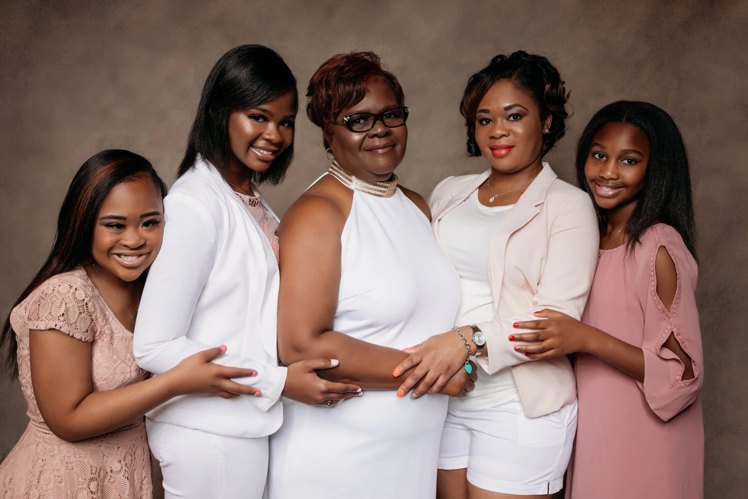 Three women posing together in black outfits during a professional studio portrait session in Memphis TN