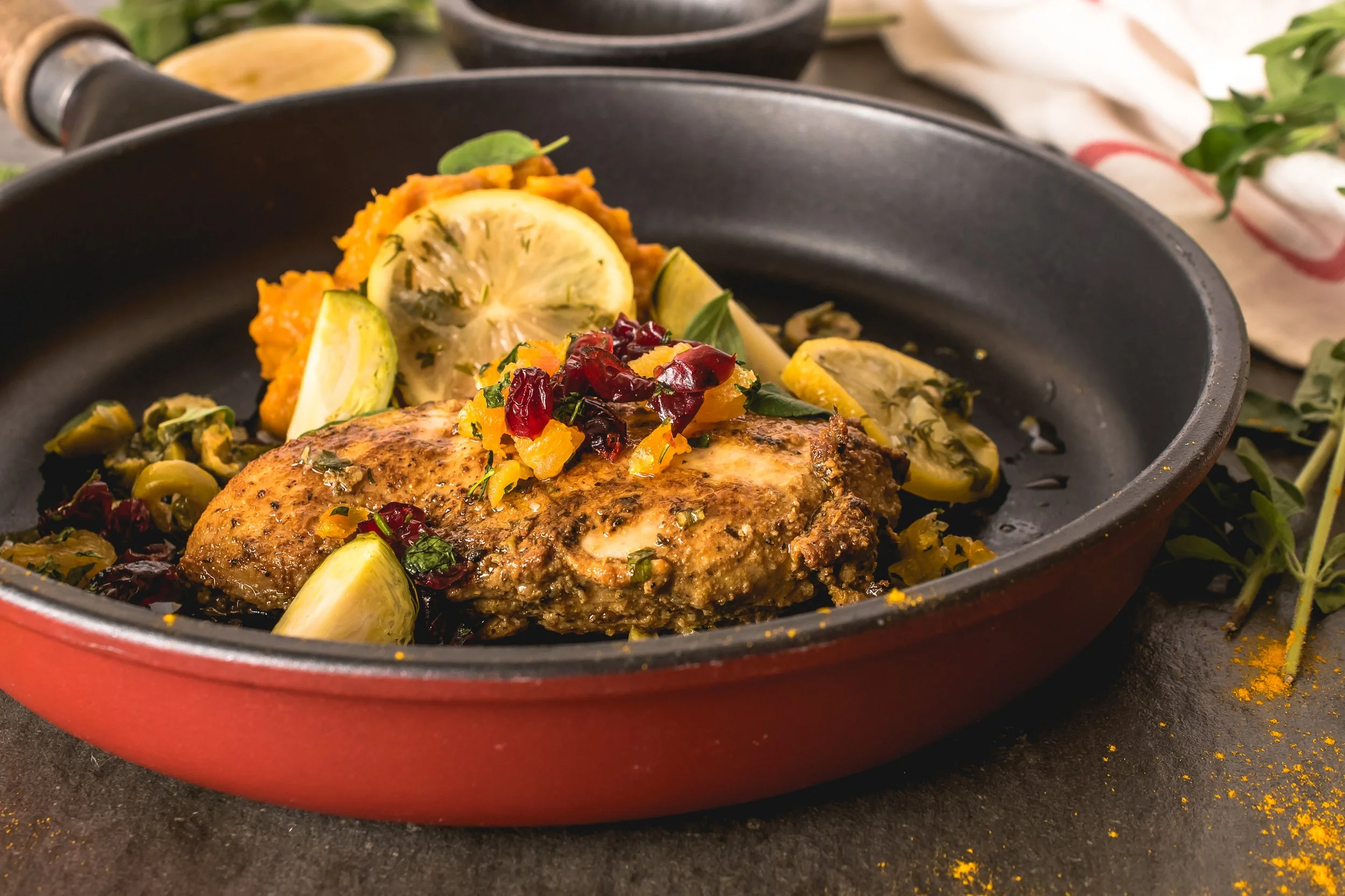  A dish of roasted chicken served with lemon and sweet potatoes.   