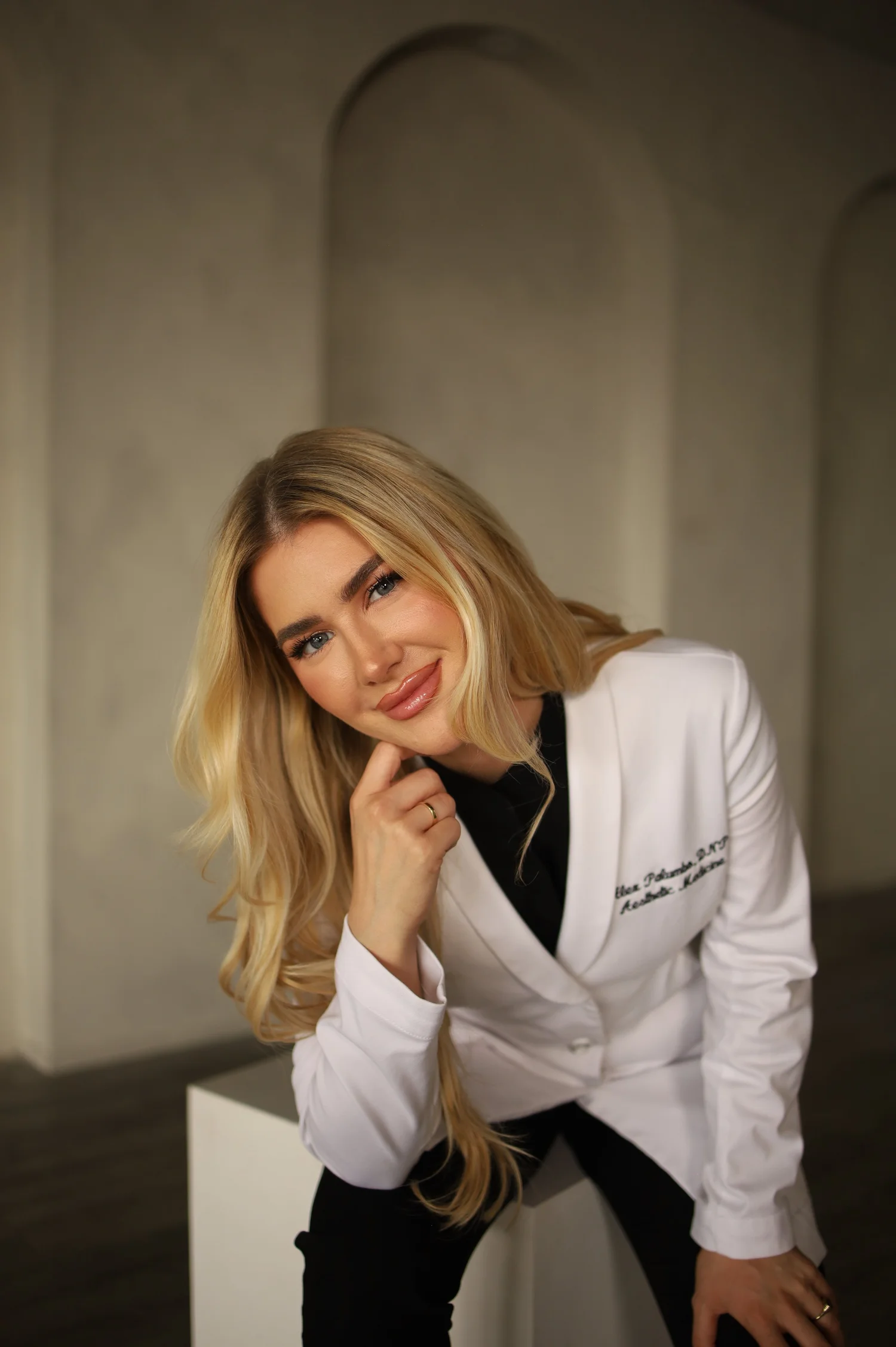 Dr. Alex, DNP, APRN, FNP-C, founder of Blonde Girl Aesthetics, in her white coat