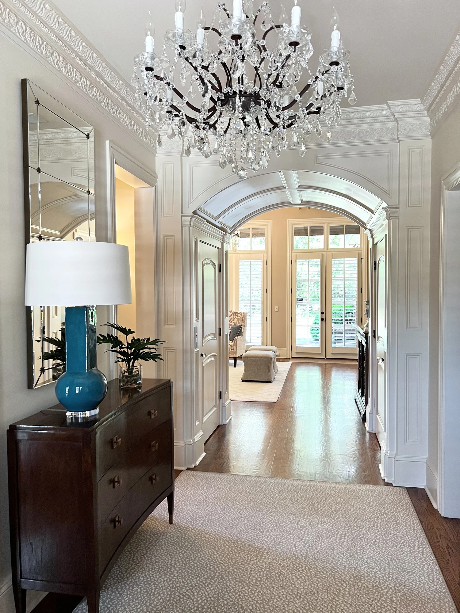 Hynes Landing foyer with chandelier and arched passage