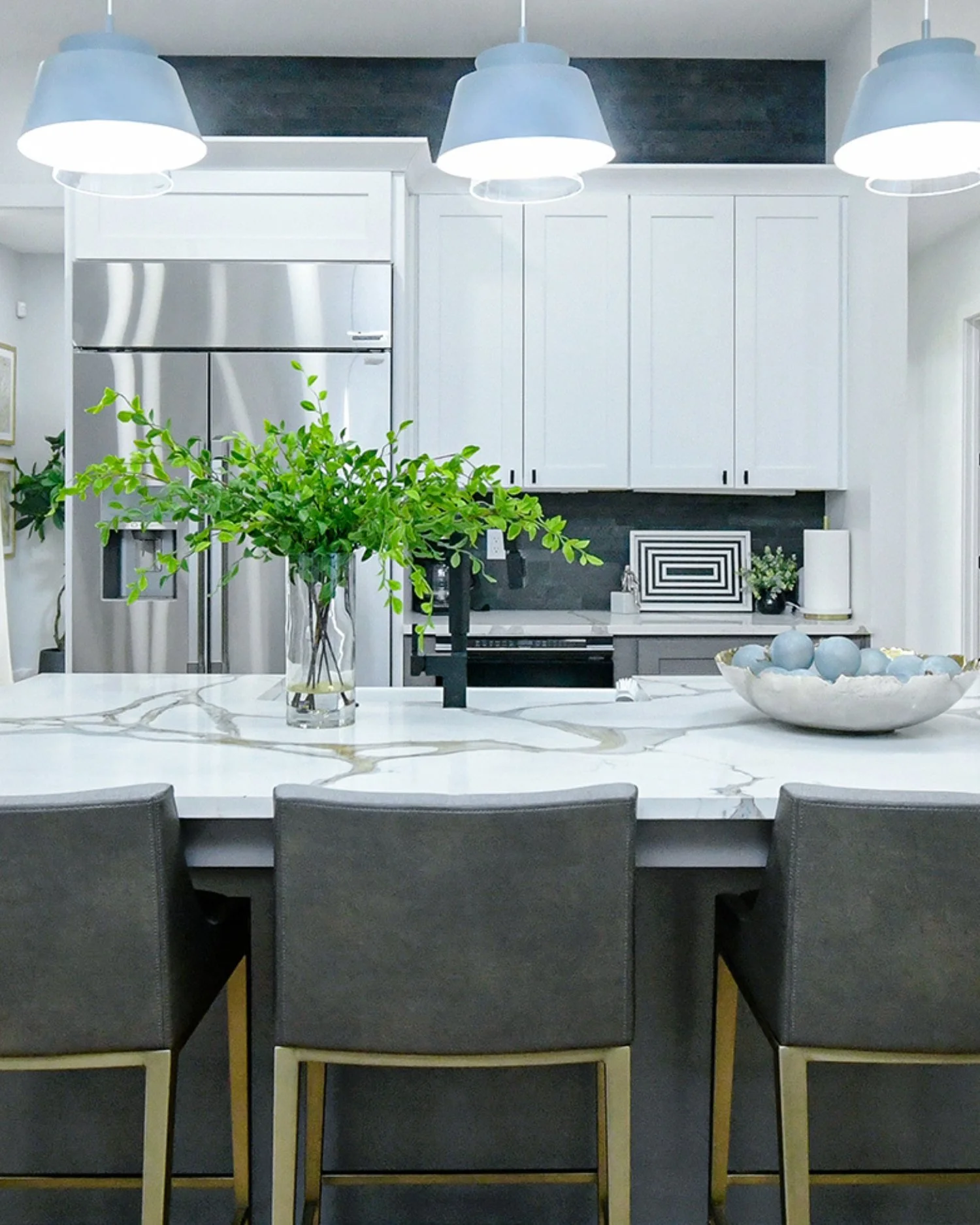 Ridgedale kitchen island with marble countertop, sculptural pendants, and styled greenery