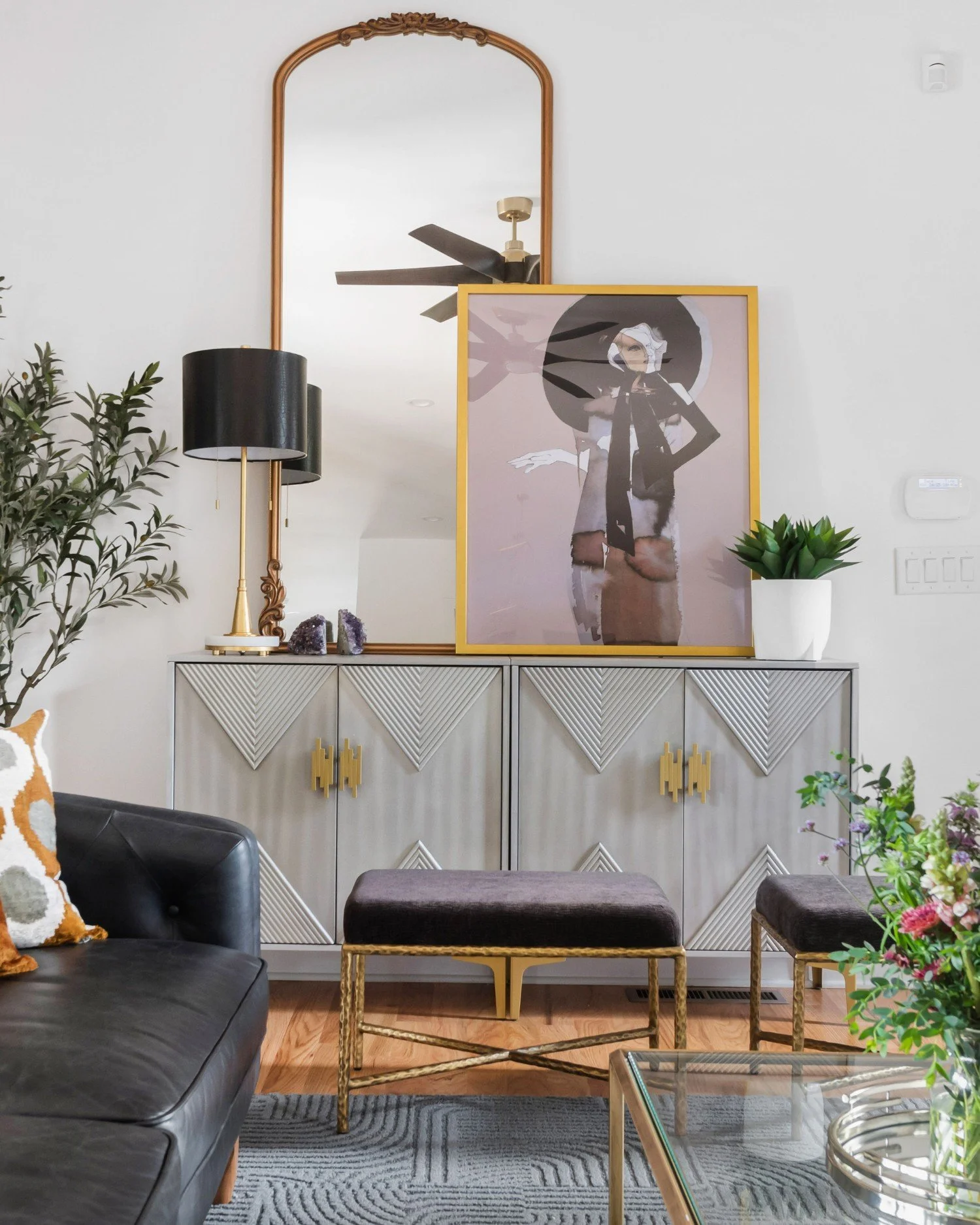 Console styling detail with mirror, art, and lamp