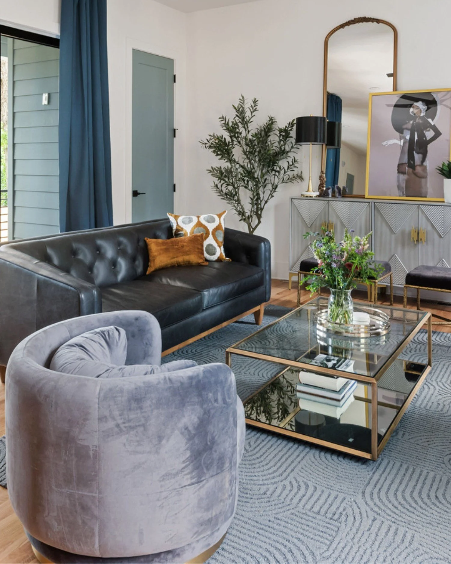 Monument Avenue living room with black sofa, velvet chair, and glass coffee table
