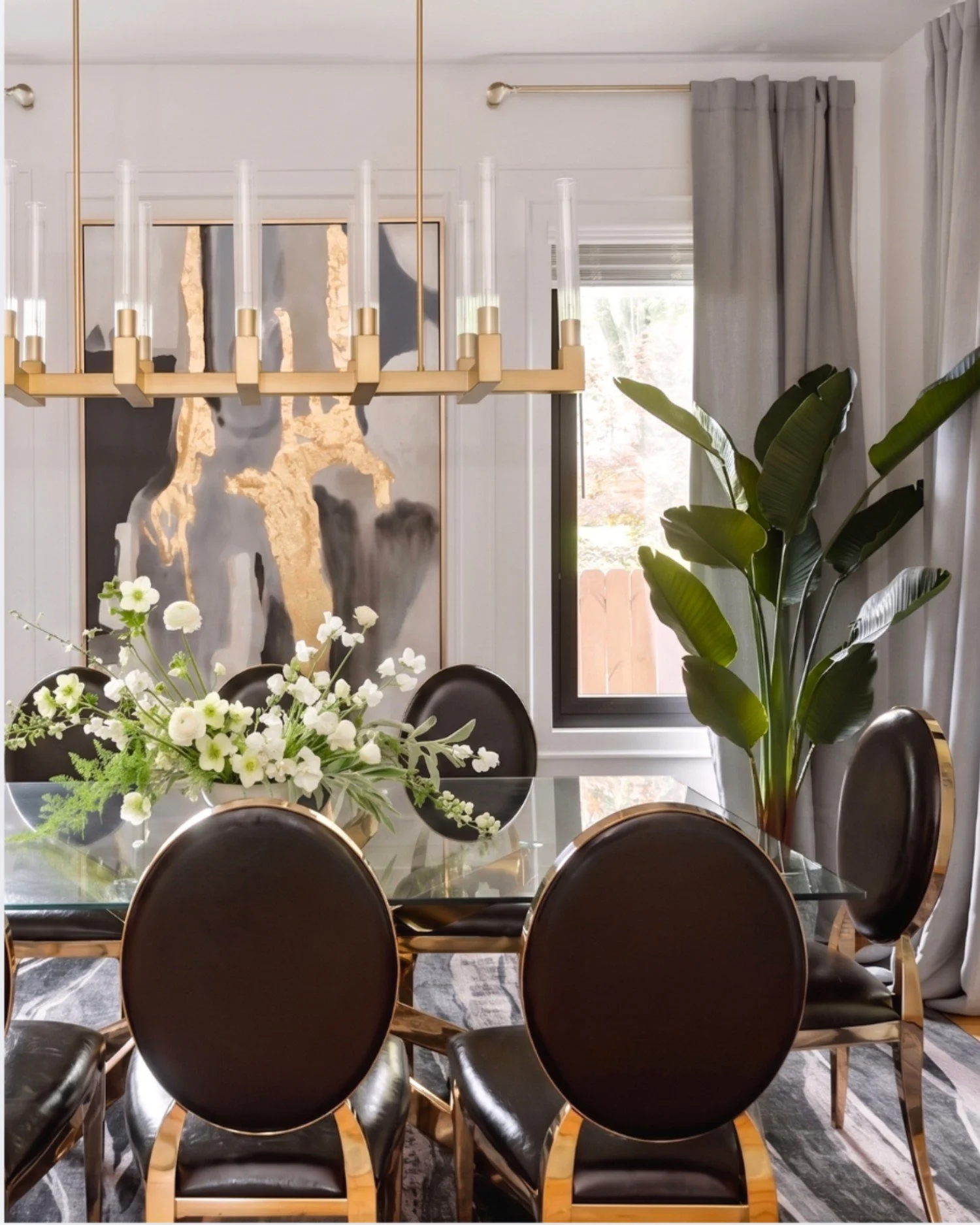 Monument Avenue dining room with chandelier, black chairs, and floral centerpiece