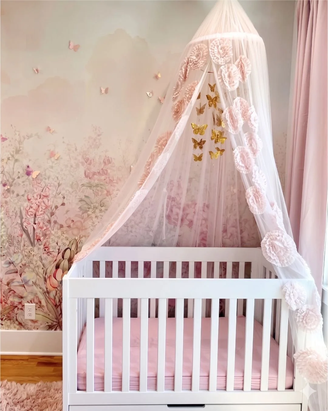 Canopy crib layered against the floral mural in A Room in Bloom