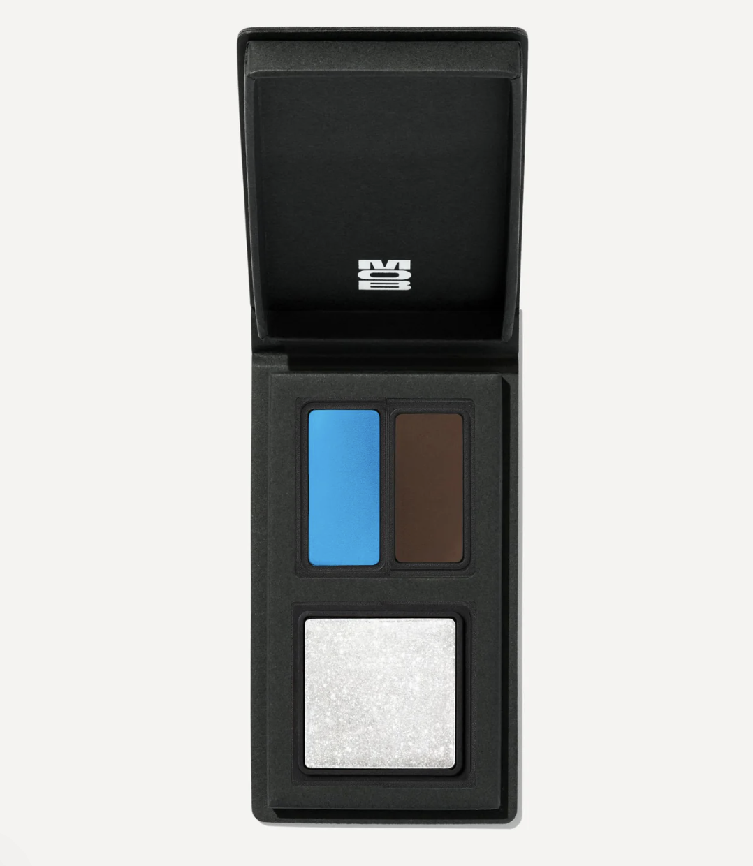 Open MOB Beauty compact featuring bold blue and brown eyeshadows alongside a shimmering highlighter in a refillable case.