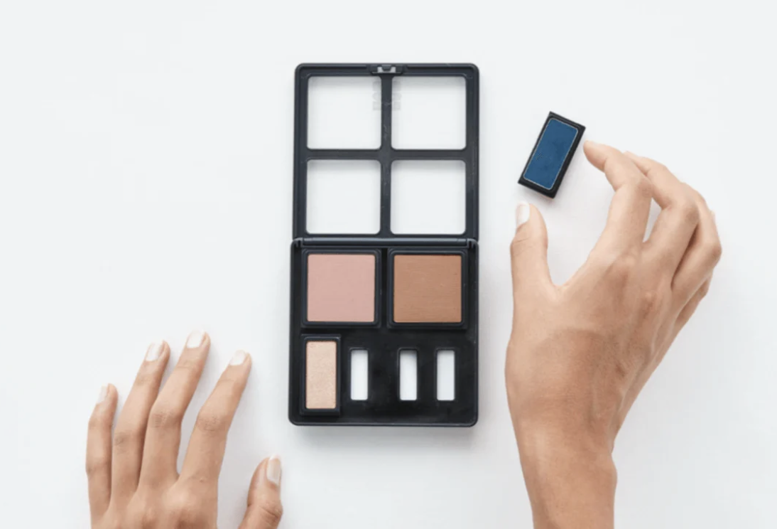 Hands placing a refill pan into a customizable MOB Beauty makeup palette, demonstrating the refillable design system.