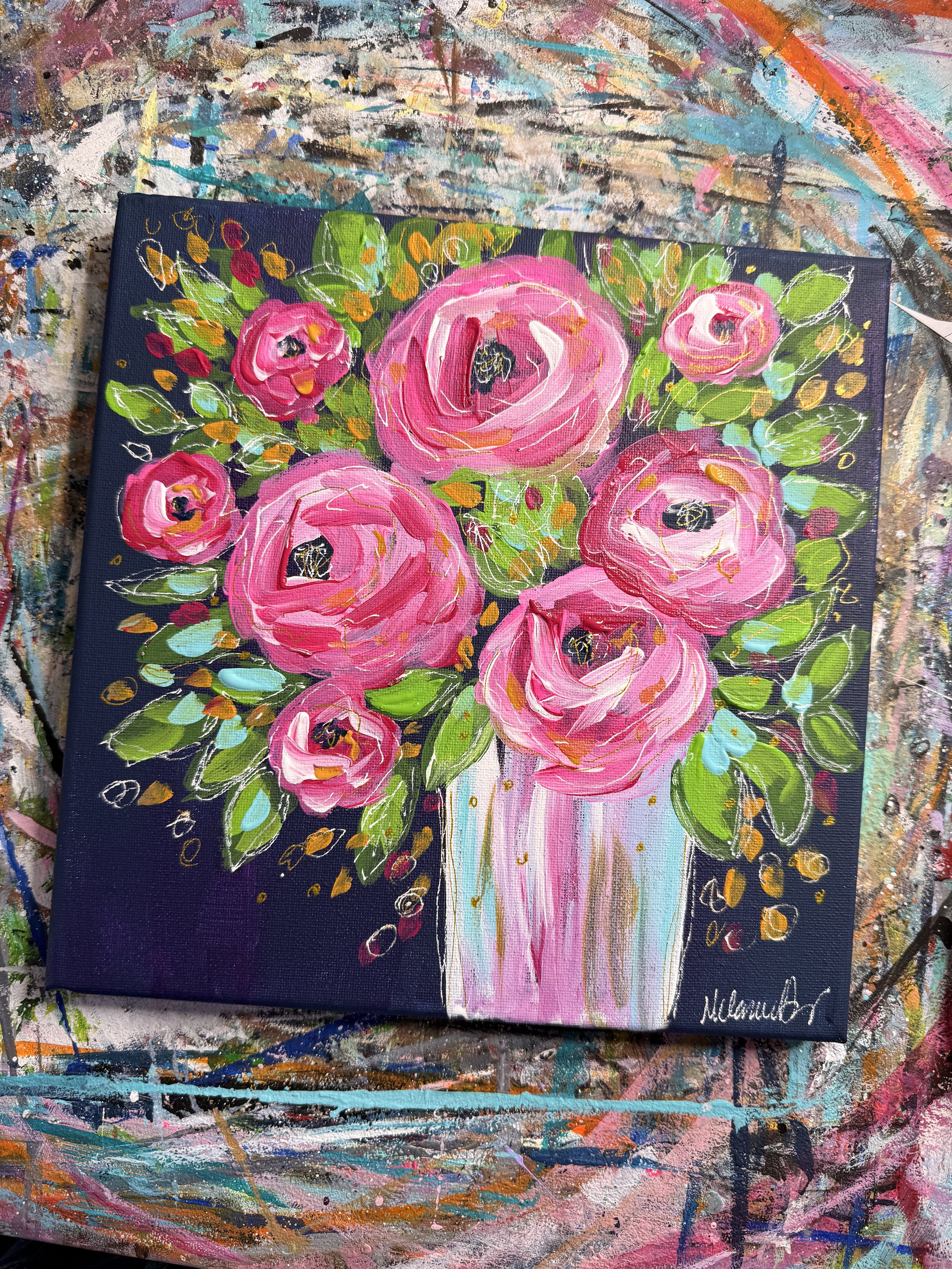 A vibrant acrylic painting of pink roses with green leaves arranged in a white vase on a dark background. The painting is signed by the artist in the bottom right corner.