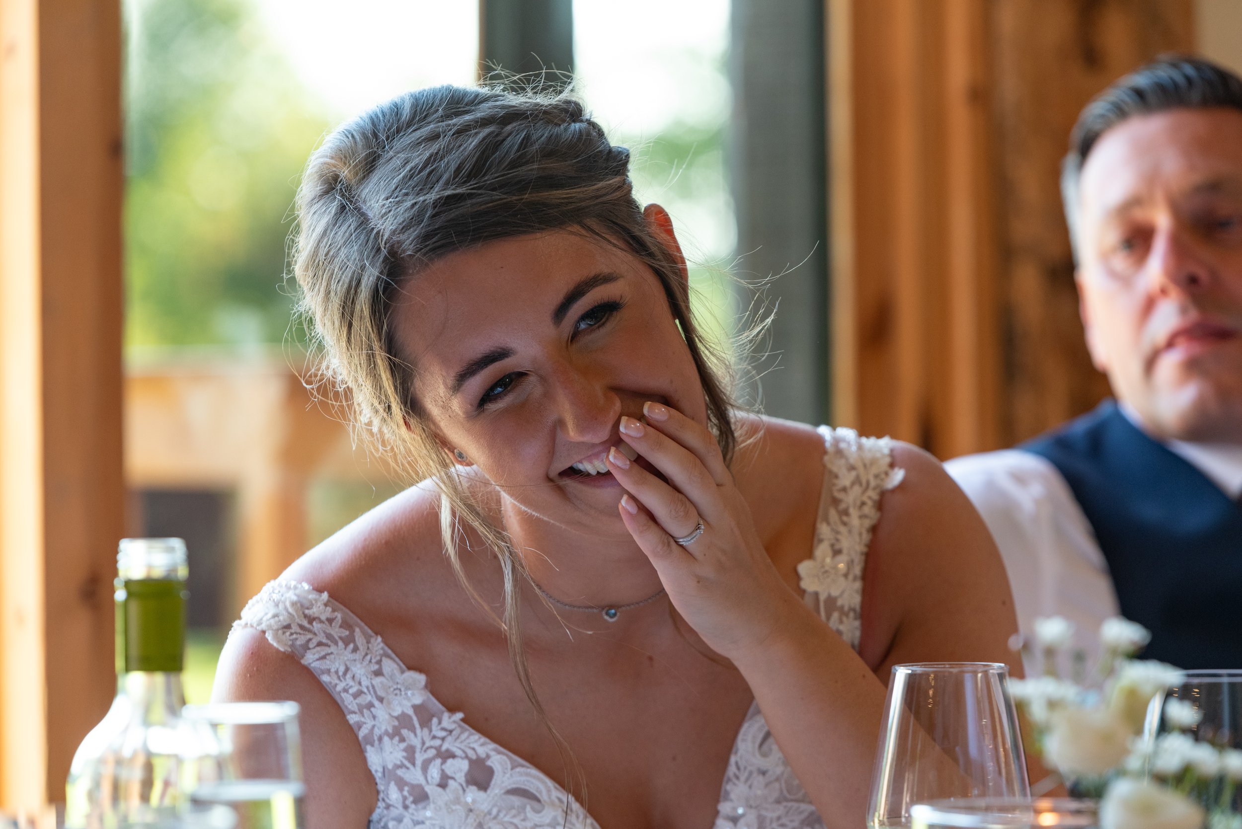  bride covering mouth while laughing at best man speech 