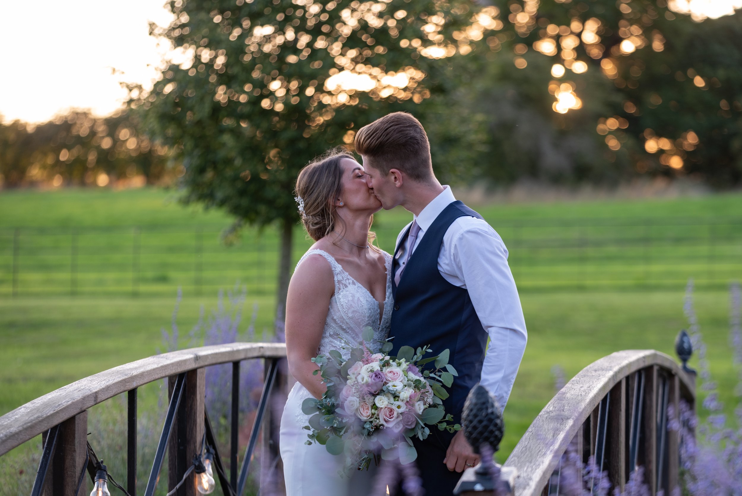  bride and groom sharing a kiss on bridge 