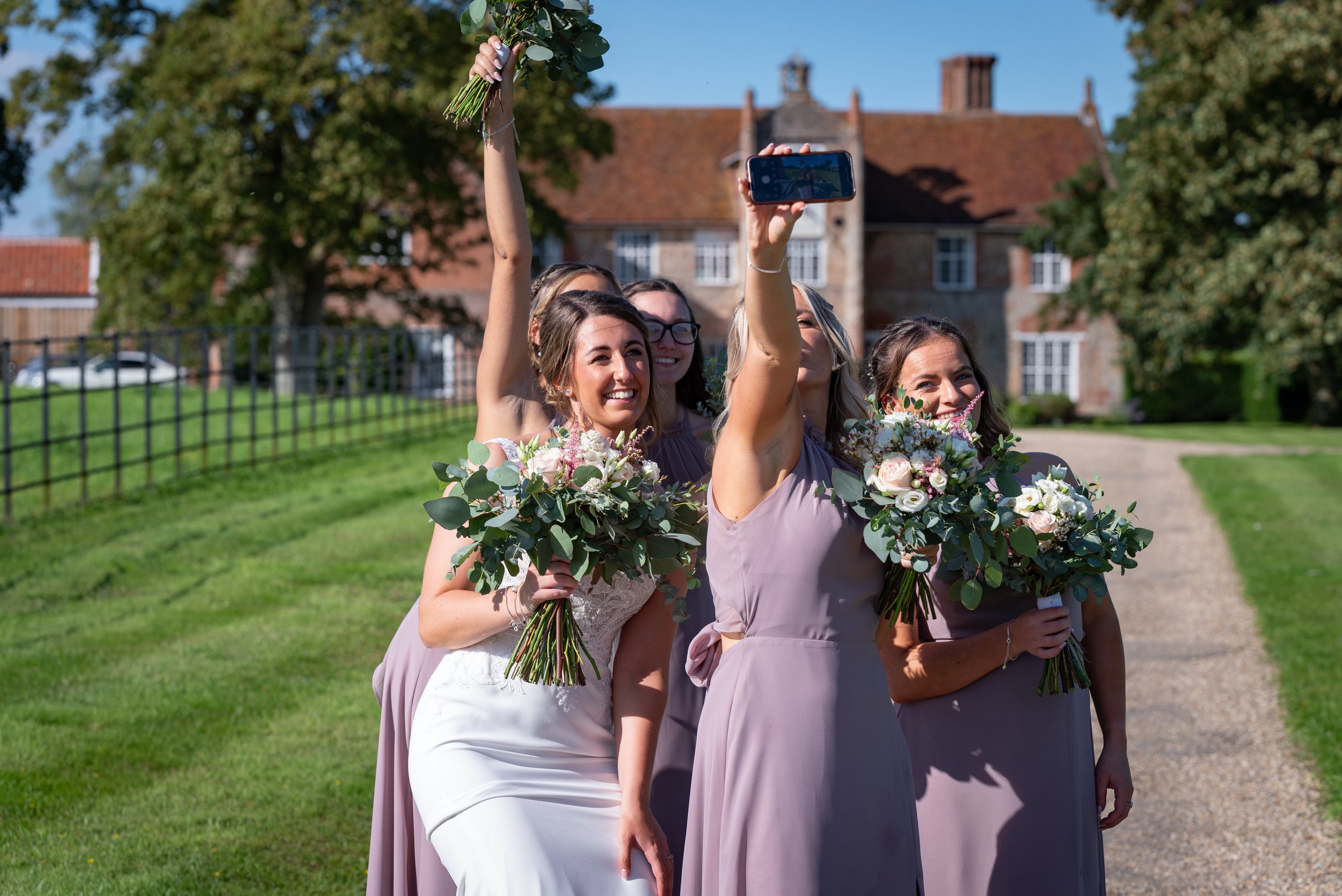  bride and bridesmaids taking a selfie 
