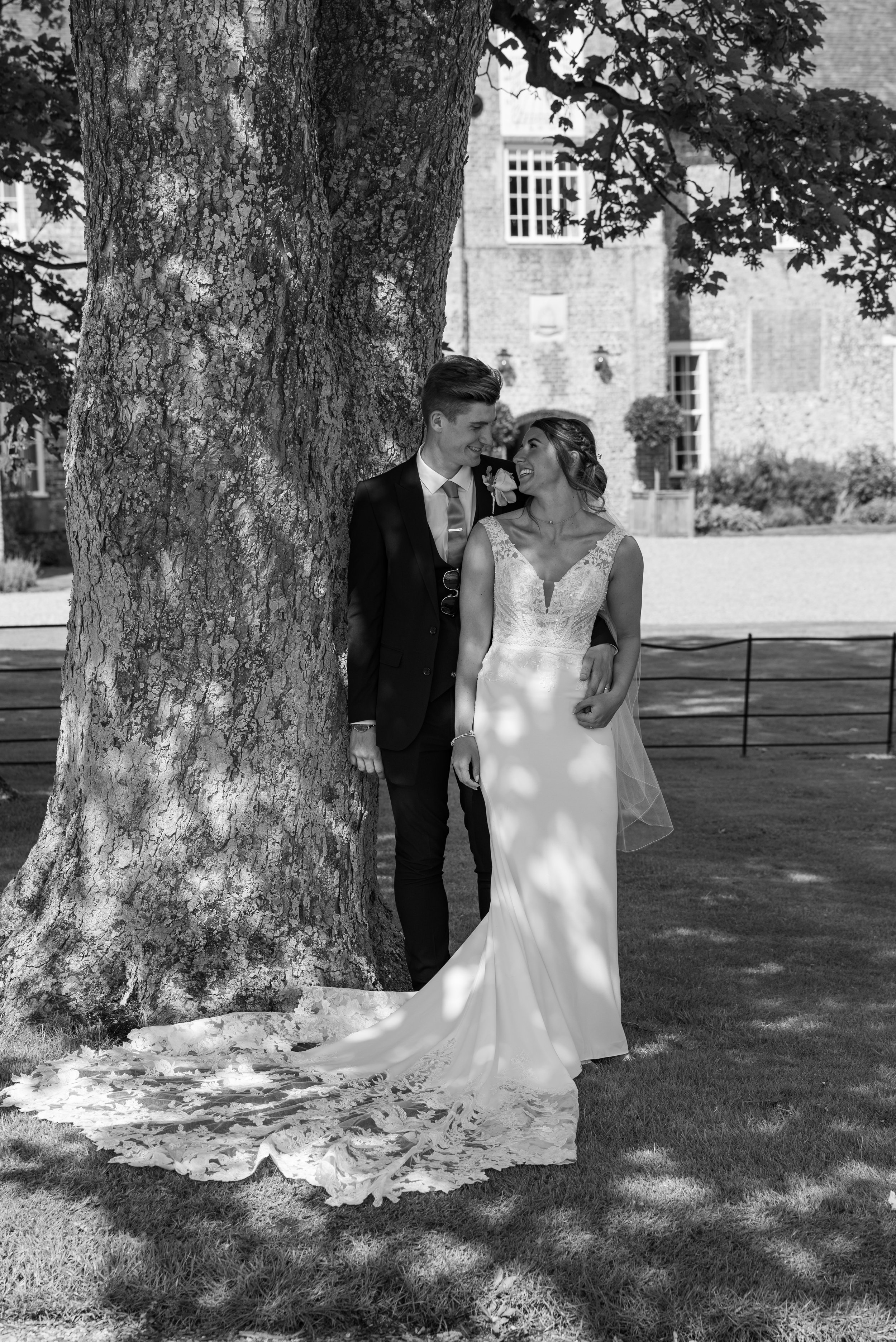  bride and groom posing by tree 