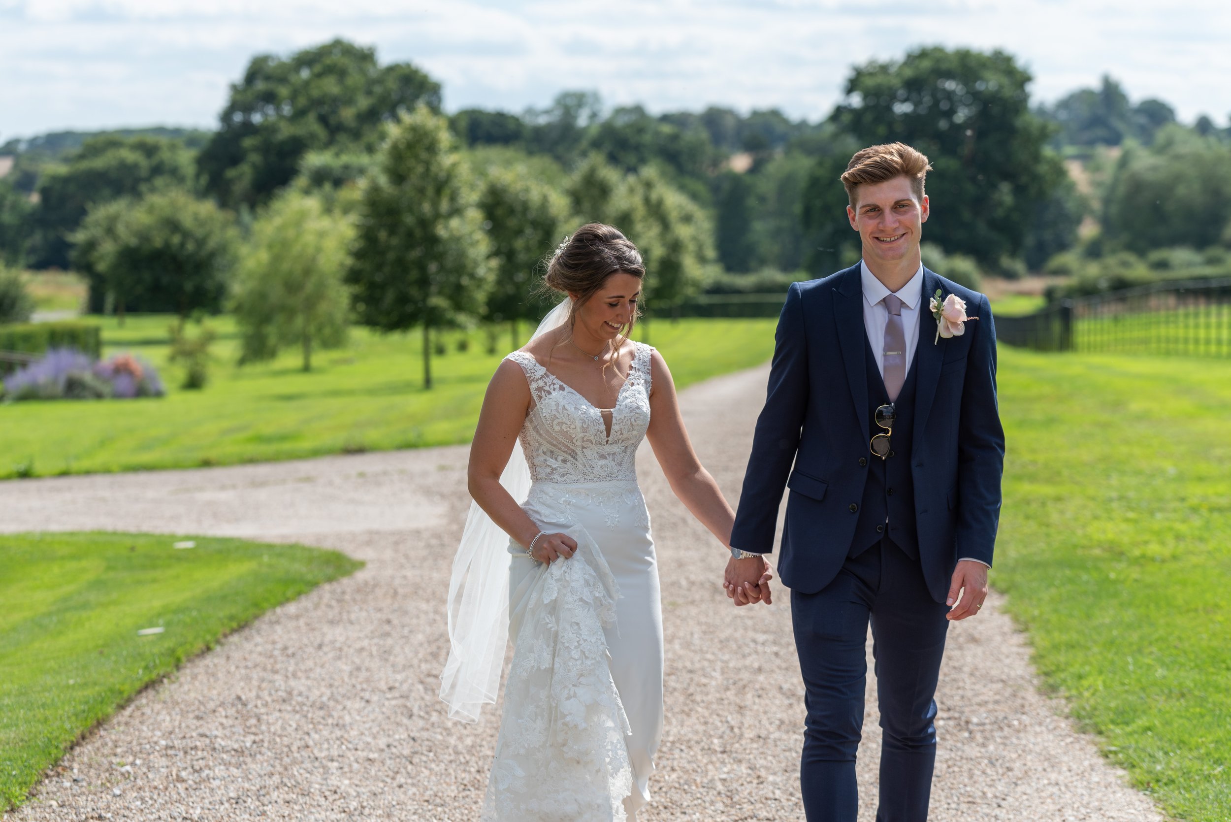  bride and groom walking in grounds at wedding venue 