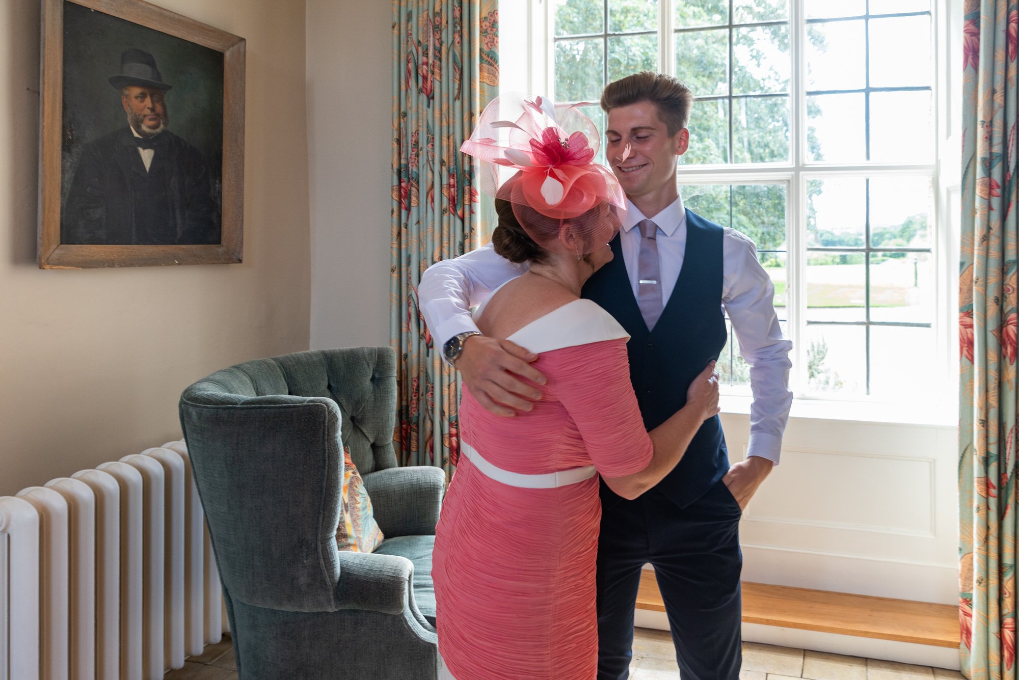  groom and mother sharing embrace before wedding ceremony 