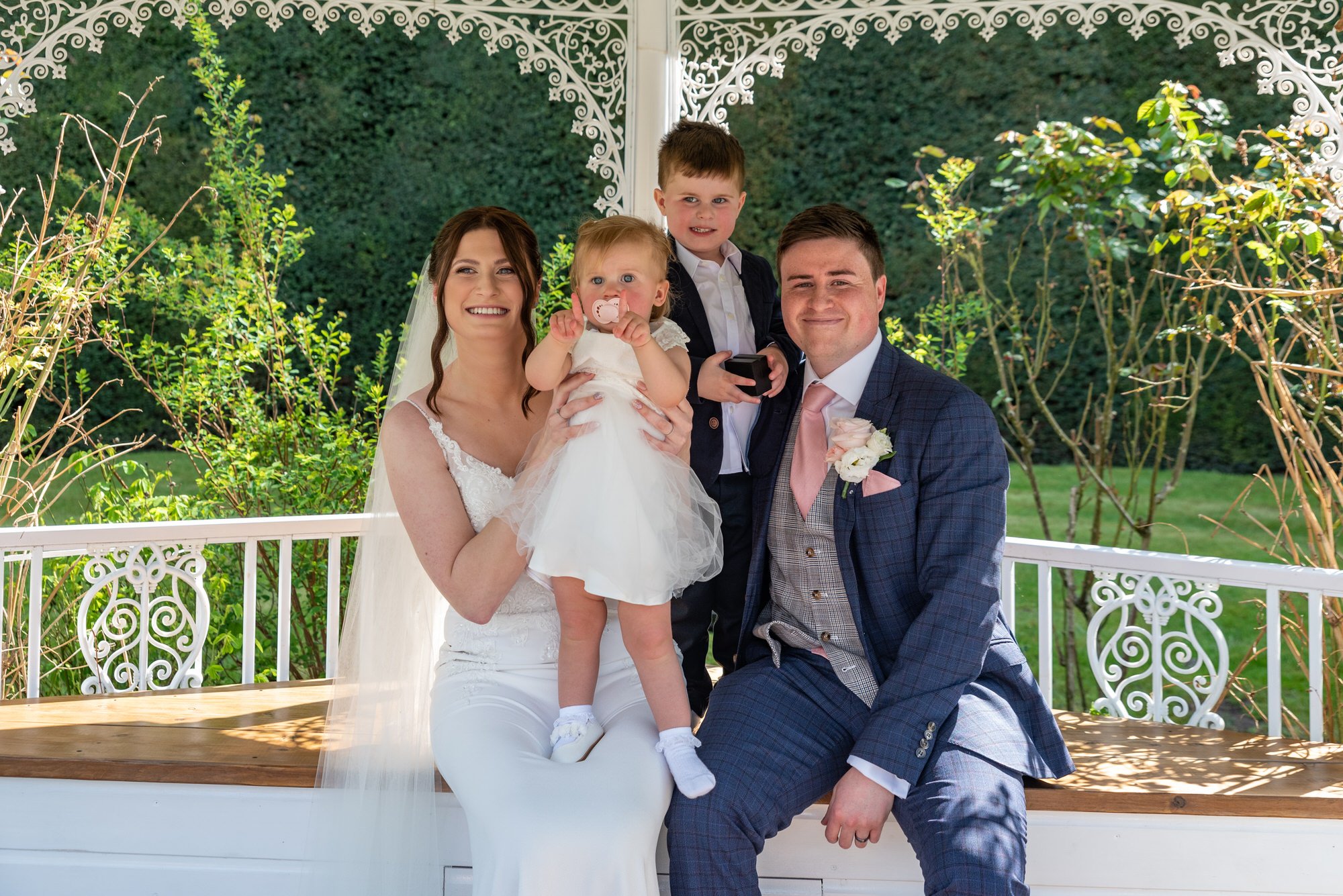  bride and groom posing with children at Suffolk wedding venue 