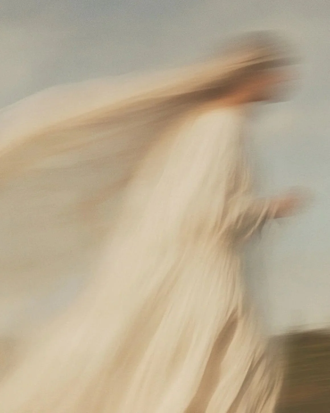 A blurry, abstract image with streaks of beige and brown colors. No clear objects or details are visible.