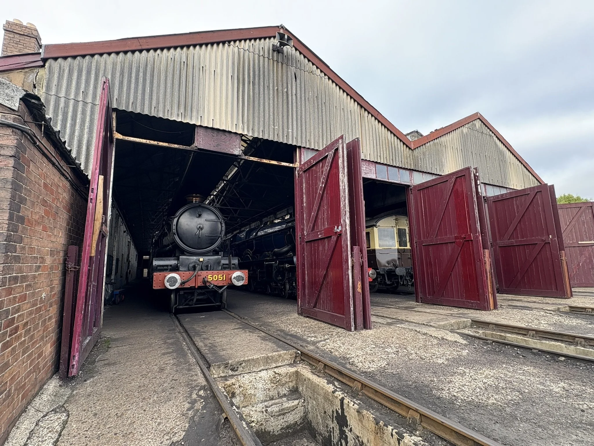 photograph of a train engine shed with a steam train