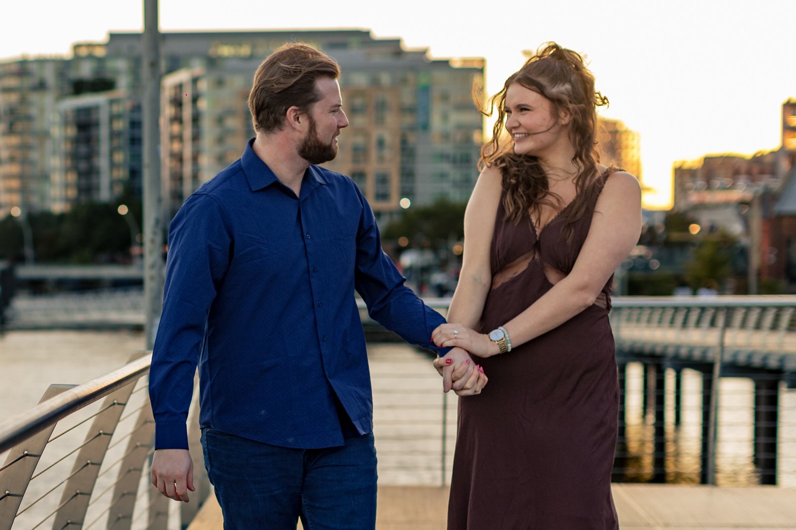 A man is proposing to his girlfriend in front of the Yards Park in Washington DC.
