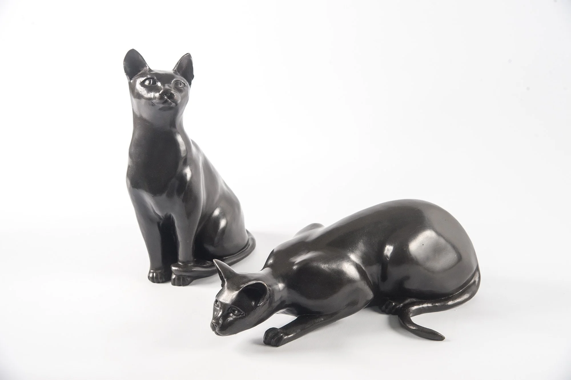 Cats – Crouching and Watching life size bronze sculptures of cats one crouching one sitting watching side view