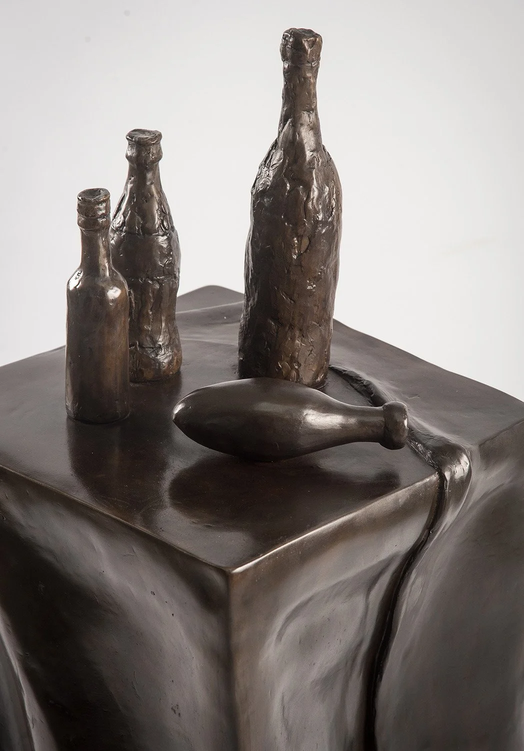 Still Life VII life size bronze sculpture of table draped tablecloth and bottles close up view