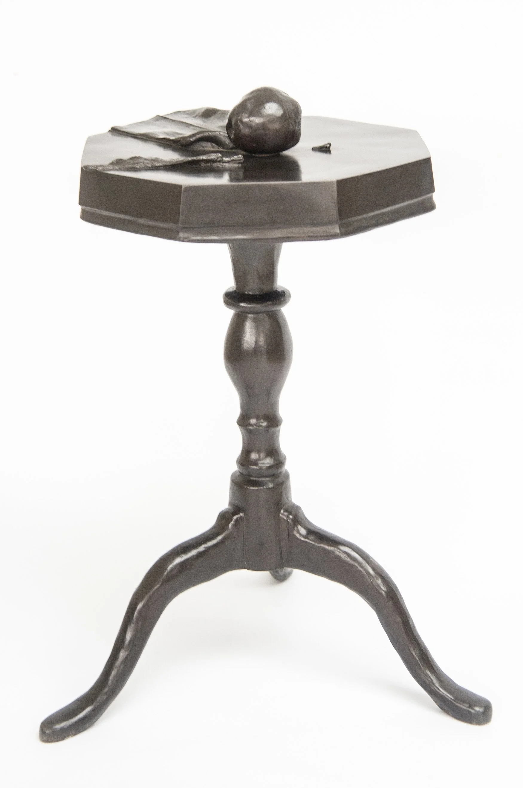Still Life V life size bronze sculpture of cloth apple and feather on octagonal table