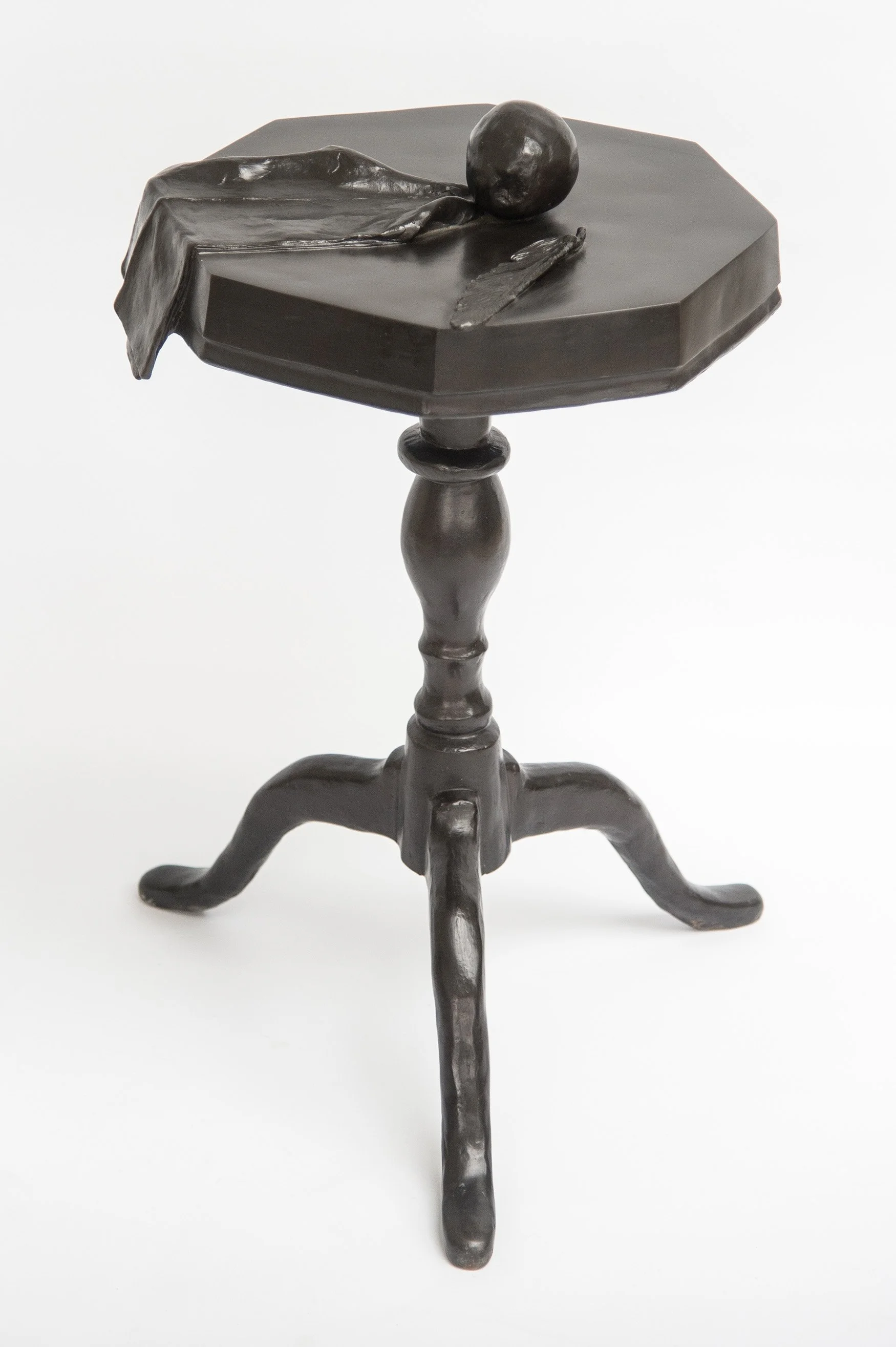 Still Life V life size bronze sculpture of cloth apple and feather on octagonal table