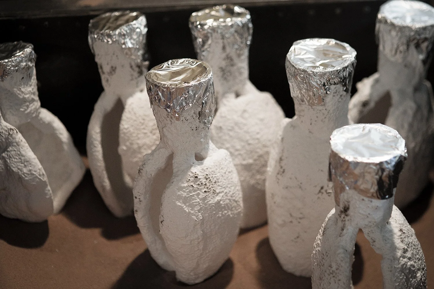 Molds prepared for bronze pour with foil tops