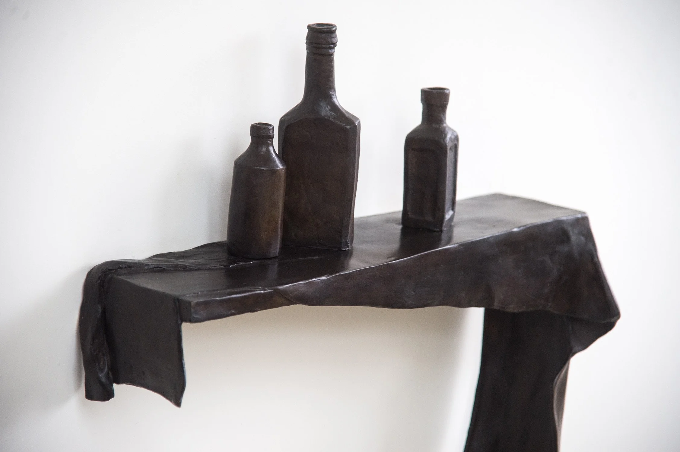 Still Life VIII life size bronze sculpture draped cloth and bottles on shelf