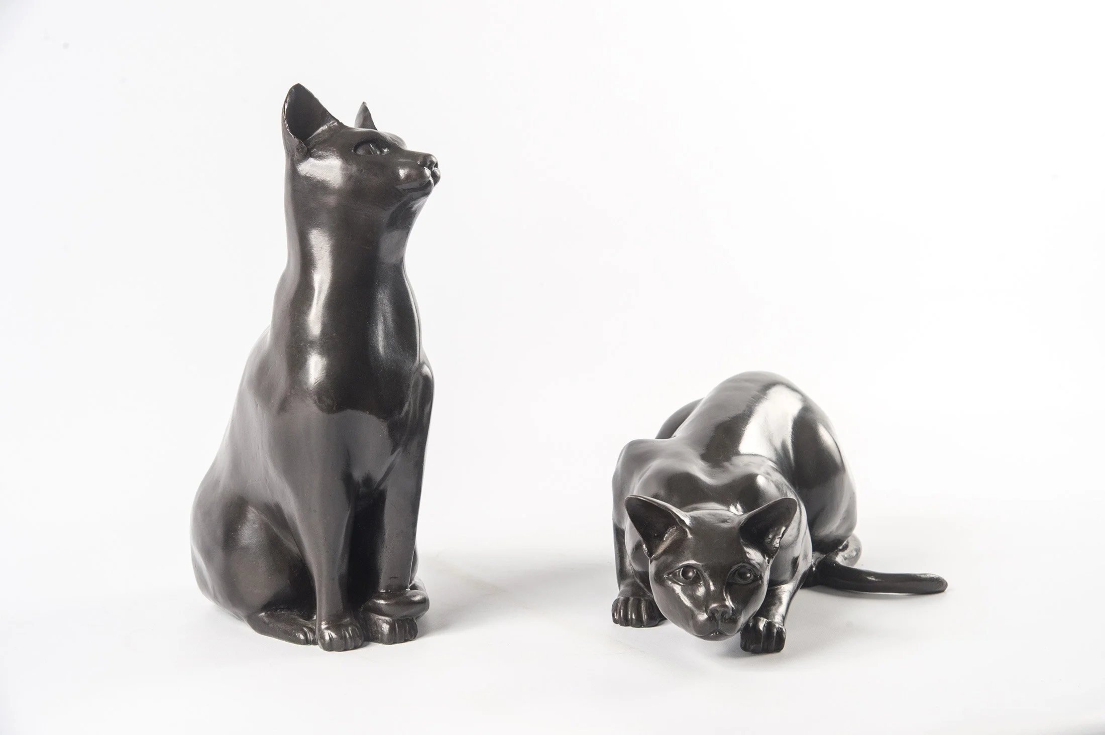 Cats – Crouching and Watching life size bronze sculptures of cats one crouching one sitting watching front view