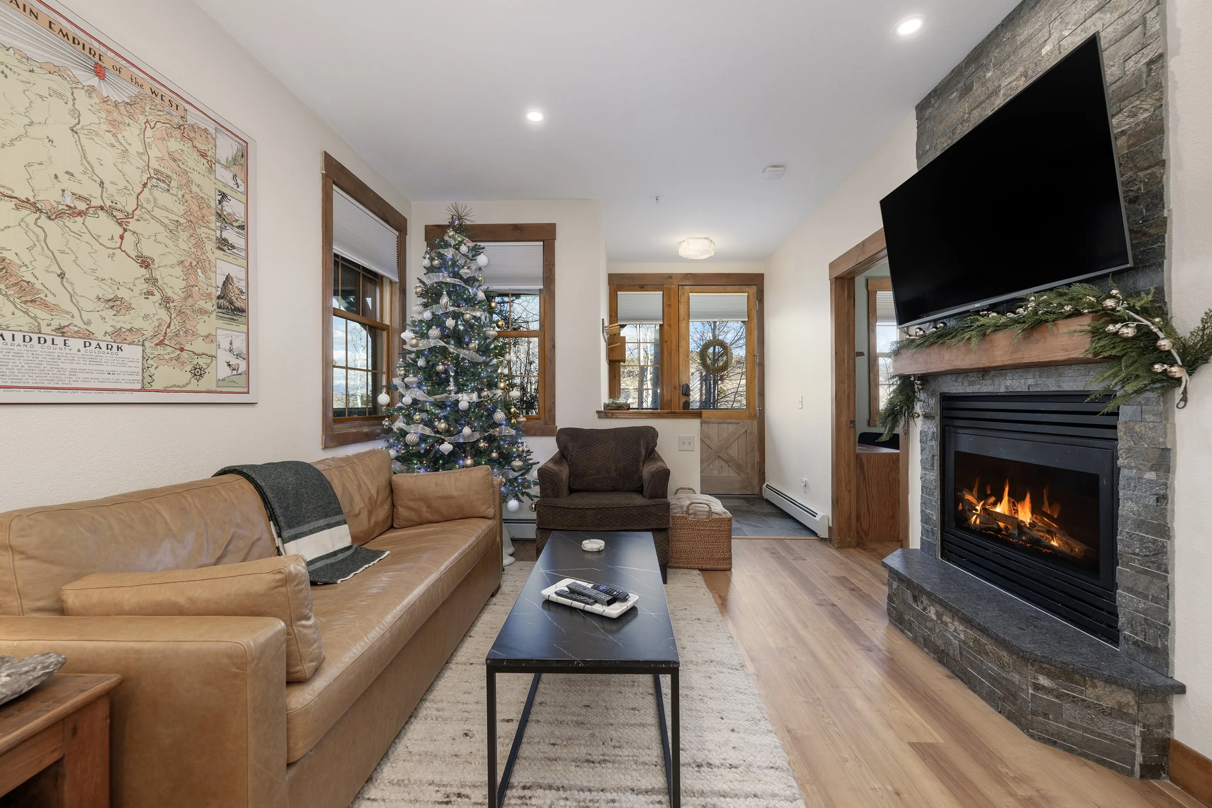 Cozy living room with gas fireplace, smart TV, and warm natural light...an inviting space for relaxing after a day outside.
