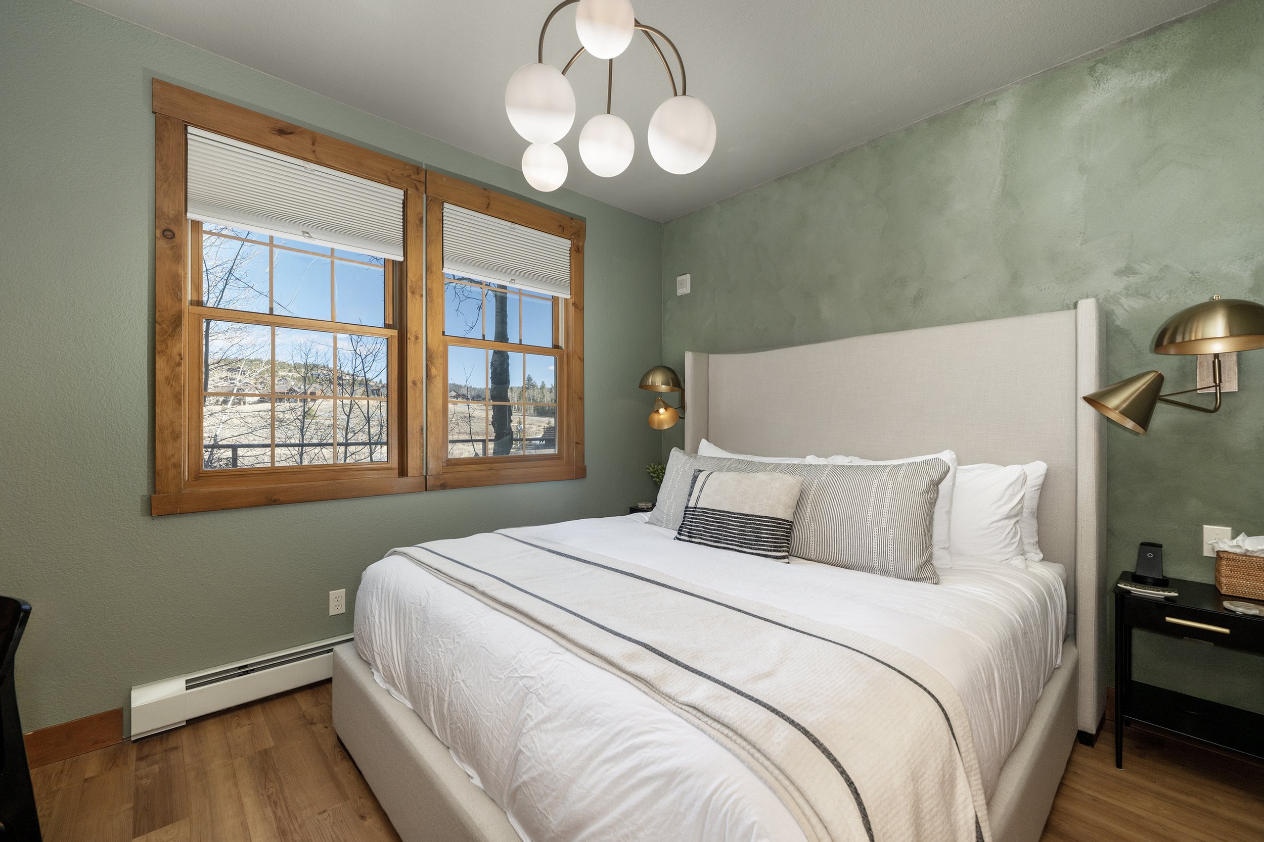 Plush king bed with luxury linens, mountain views, and warm wood trim (Blackout shades can be pulled down for both privacy and to darken the room.)