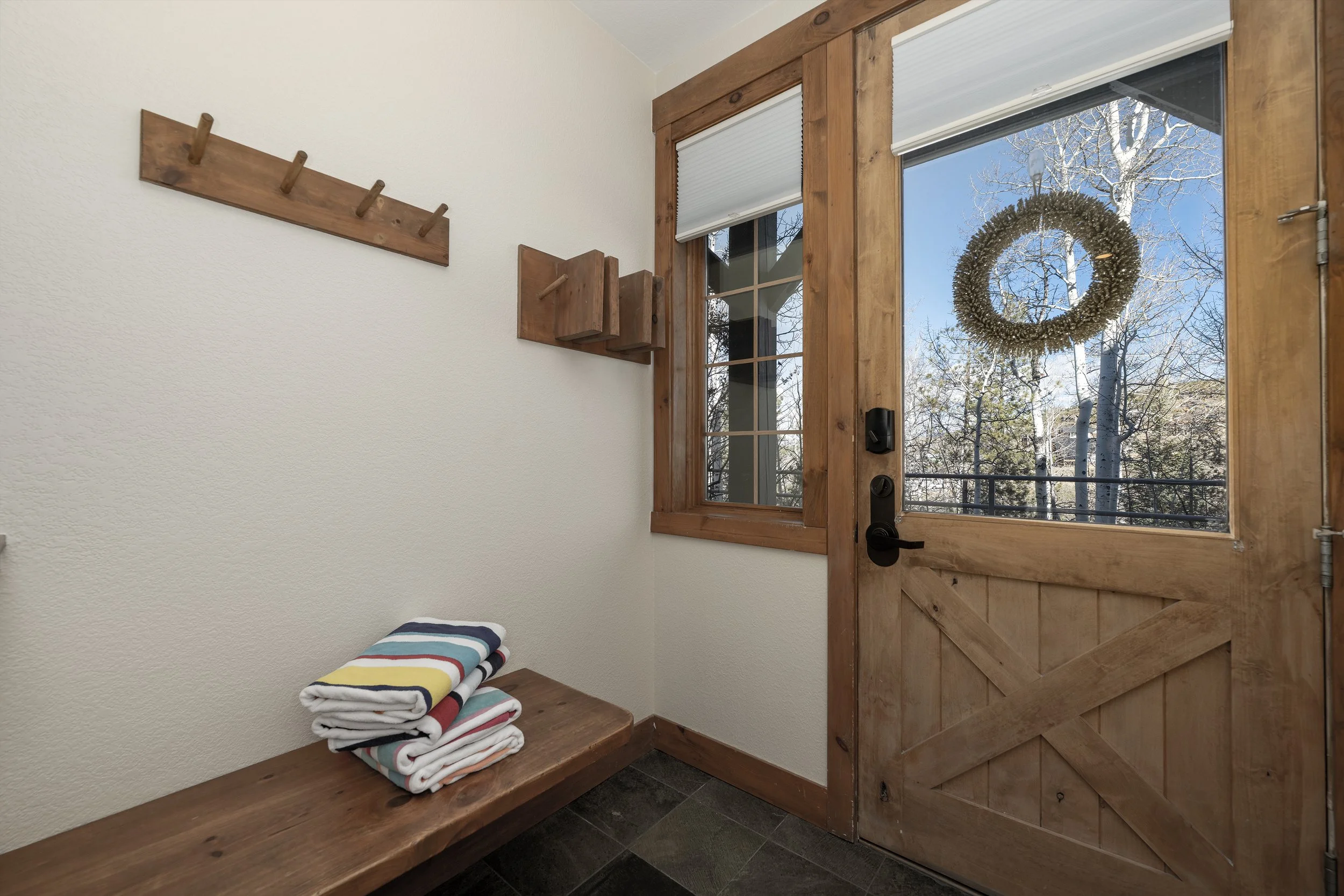Mudroom entry with hooks, bench seating, and pool towels - a convenient spot to gear up before heading out.