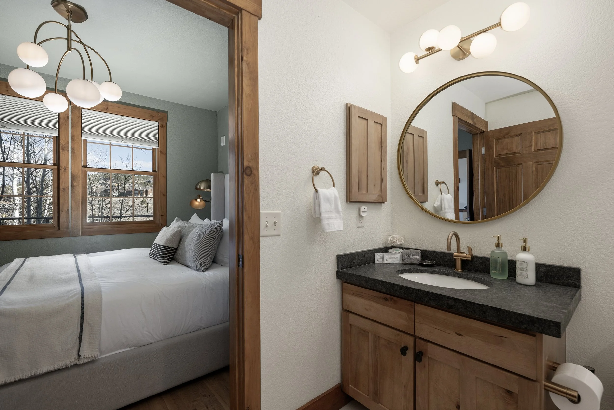 Bright ensuite setup with a modern bathroom featuring brass accents and a granite countertop, right off the cozy king bedroom.